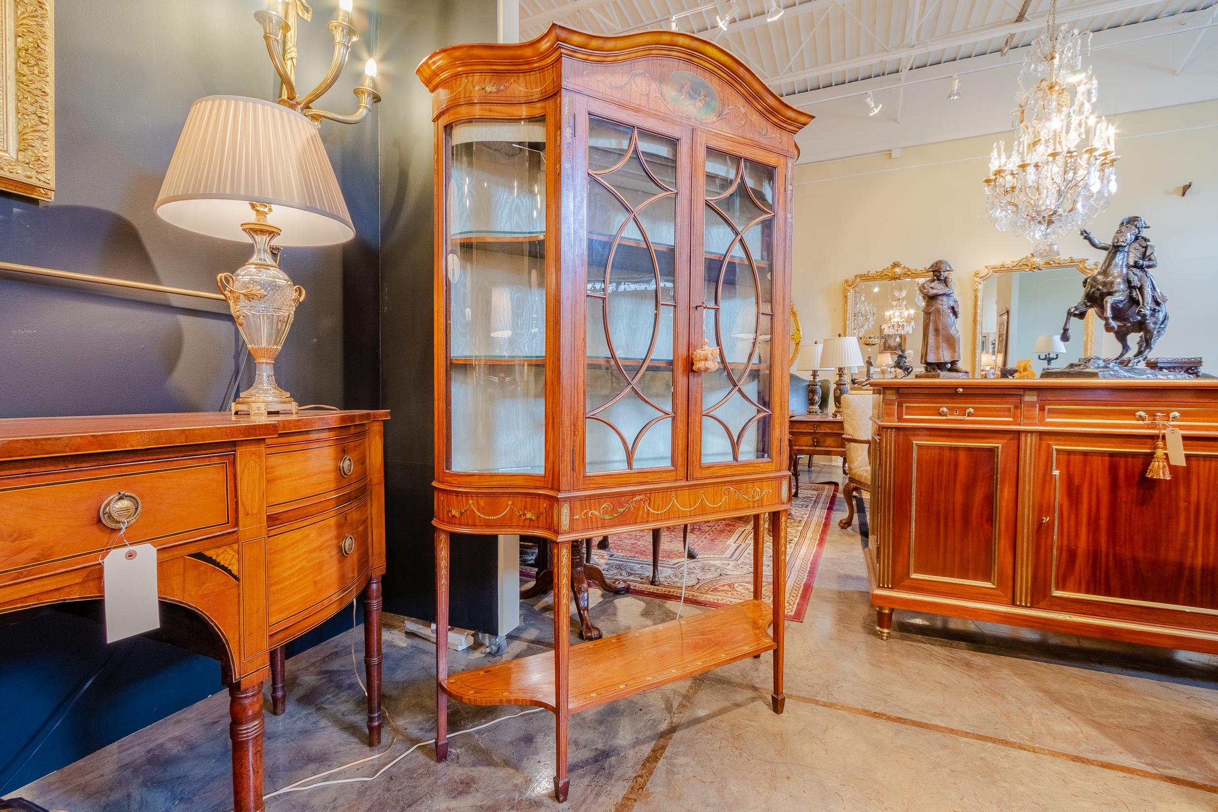 A beautiful late 19th century to early 20th century Edwardian satinwood vitrine hand painted in the style of Angelica Kaufman. Illuminated with glass shelves.