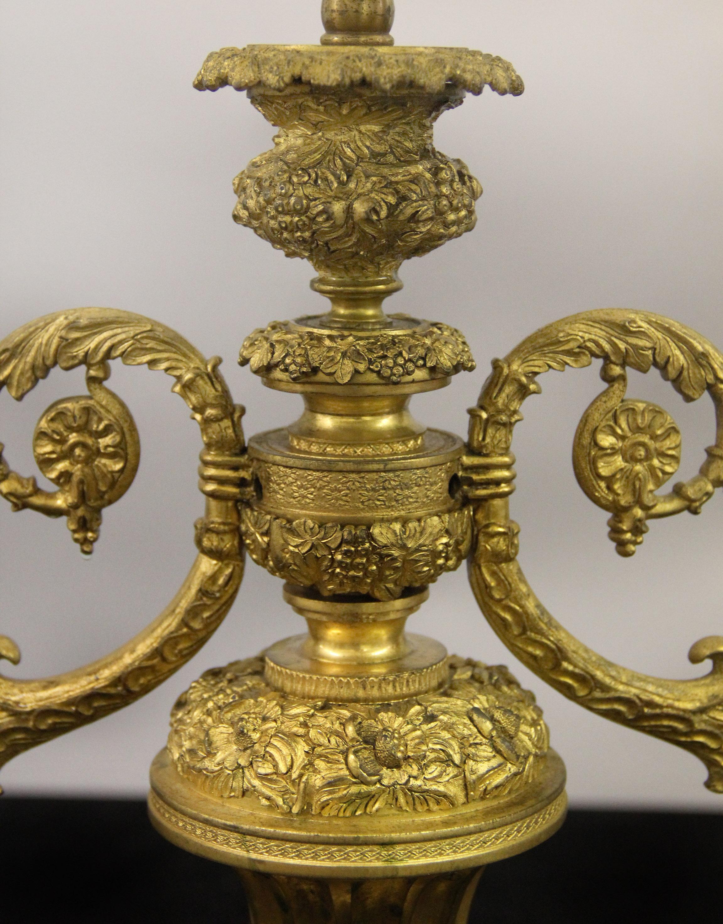 A beautiful late 19th century Empire style gilt bronze bouillotte lamp

Fantastic quality bronze lamp entirely chiseled with berries and flowers, two C scrolled arms extend with winged griffins and candle holders, the bottom with three large paws