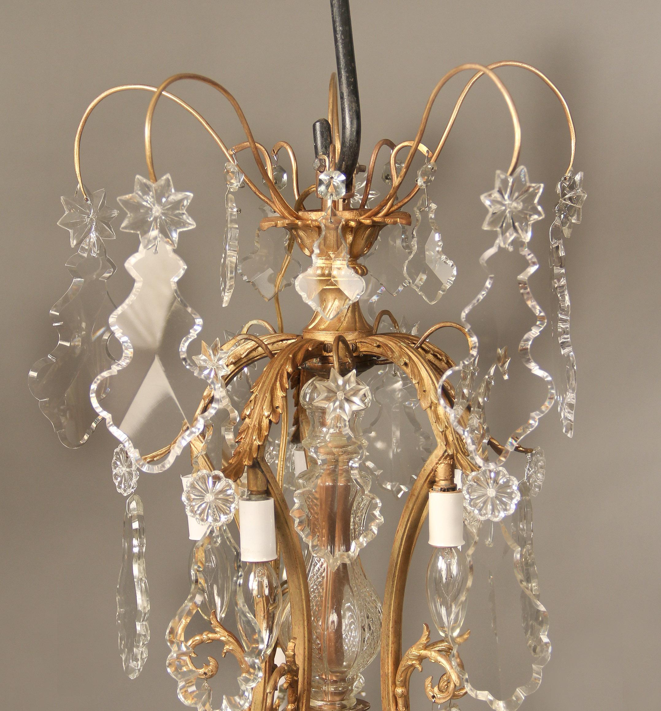 A beautiful late 19th century gilt bronze and crystal ten-light chandelier

Multi-faceted and shaped crystal, cut crystal central column with additional drop crystals, five upright spears/pendants with five perimeter and five interior lights.