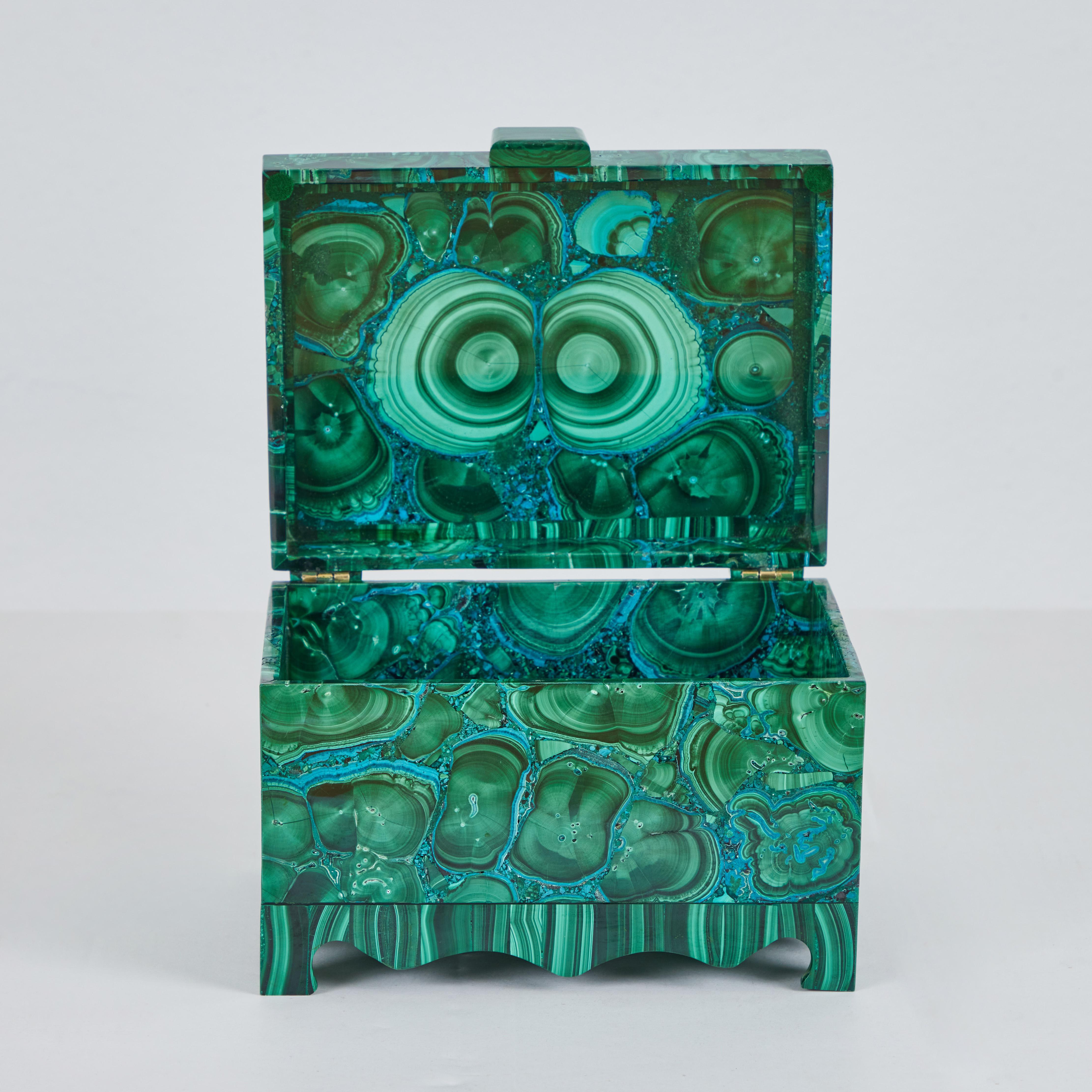 This is an absolutely beautiful malachite box. The cylindric patterns are prolific and the chrysocolla veining is impressive all around. The base with legs, lid border, knob, and hinge decor are all from one specimen, the rest of the box is from