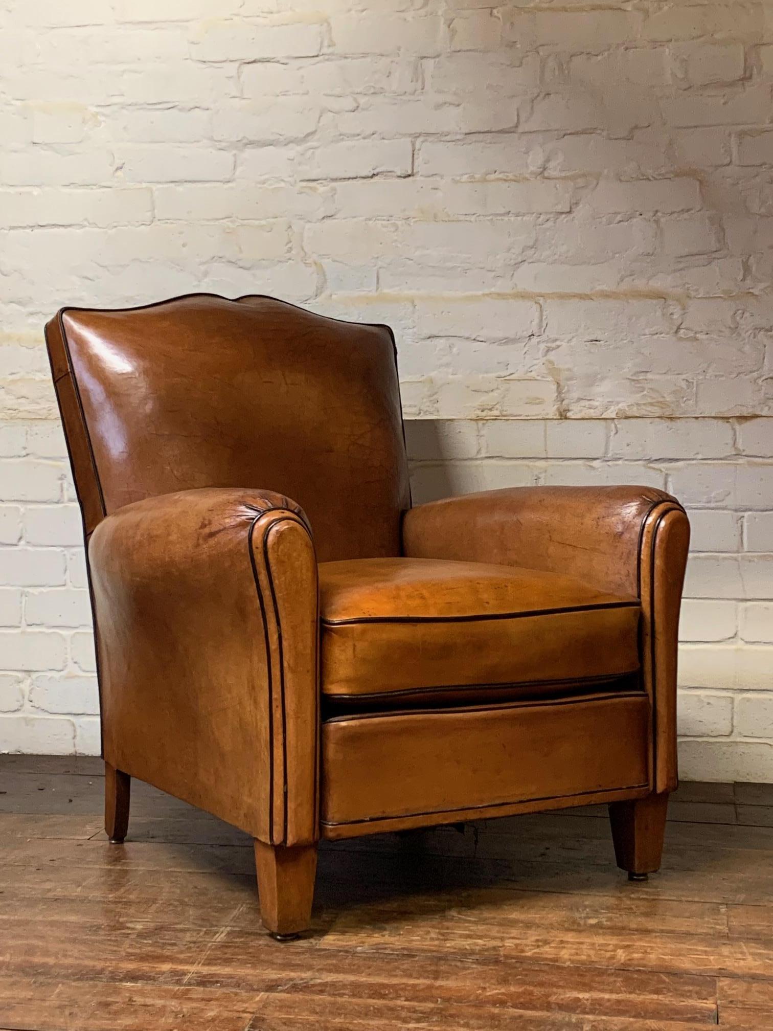 This is a beautiful chair, a classic moustache model in a fabulous condition. The leather has aged very nicely and has a lovely warm, caramel colour & patina with gorgeous deeper tones in areas. This stylish chair with its desirable contrast piping,