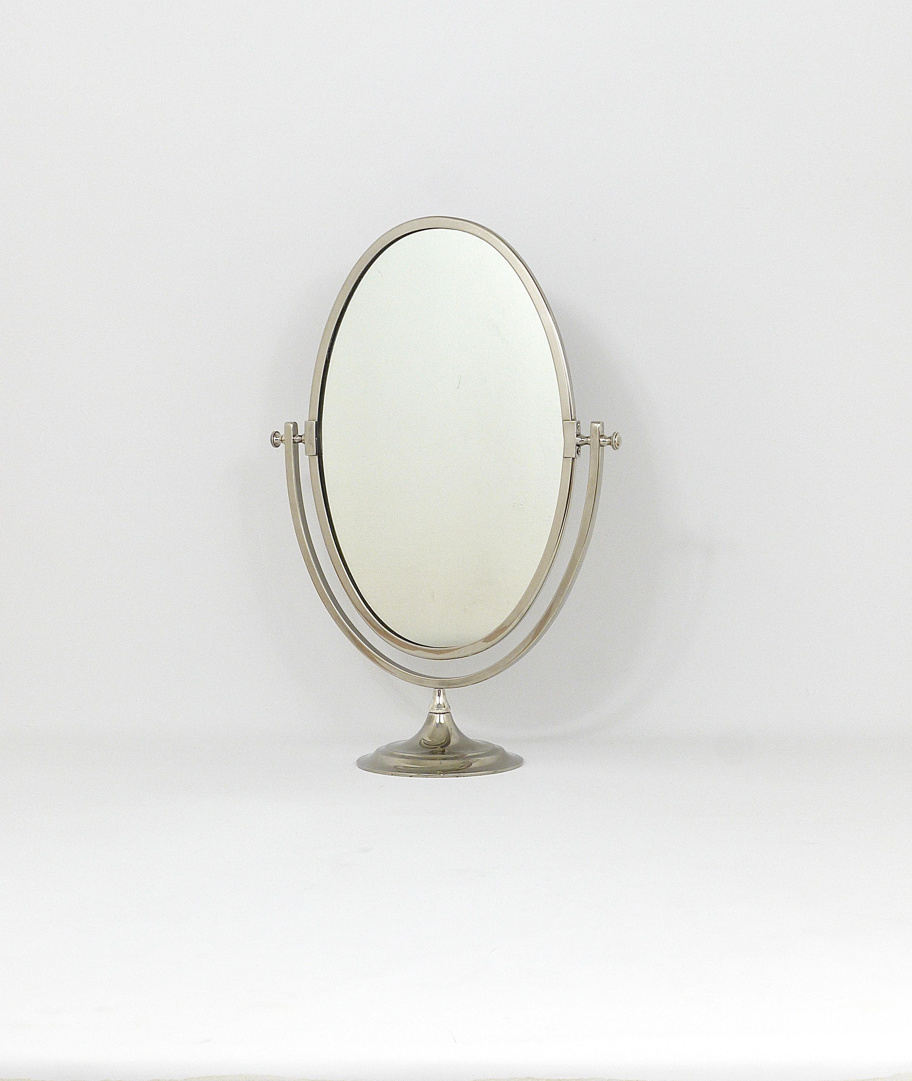 A beautiful silver plated freestanding brass table mirror from the 1950s, made in England. It has an oval mirror on a round base, which is adjustable in tilt. In very good condition with very marginal patina. The total height is 23 in. and the