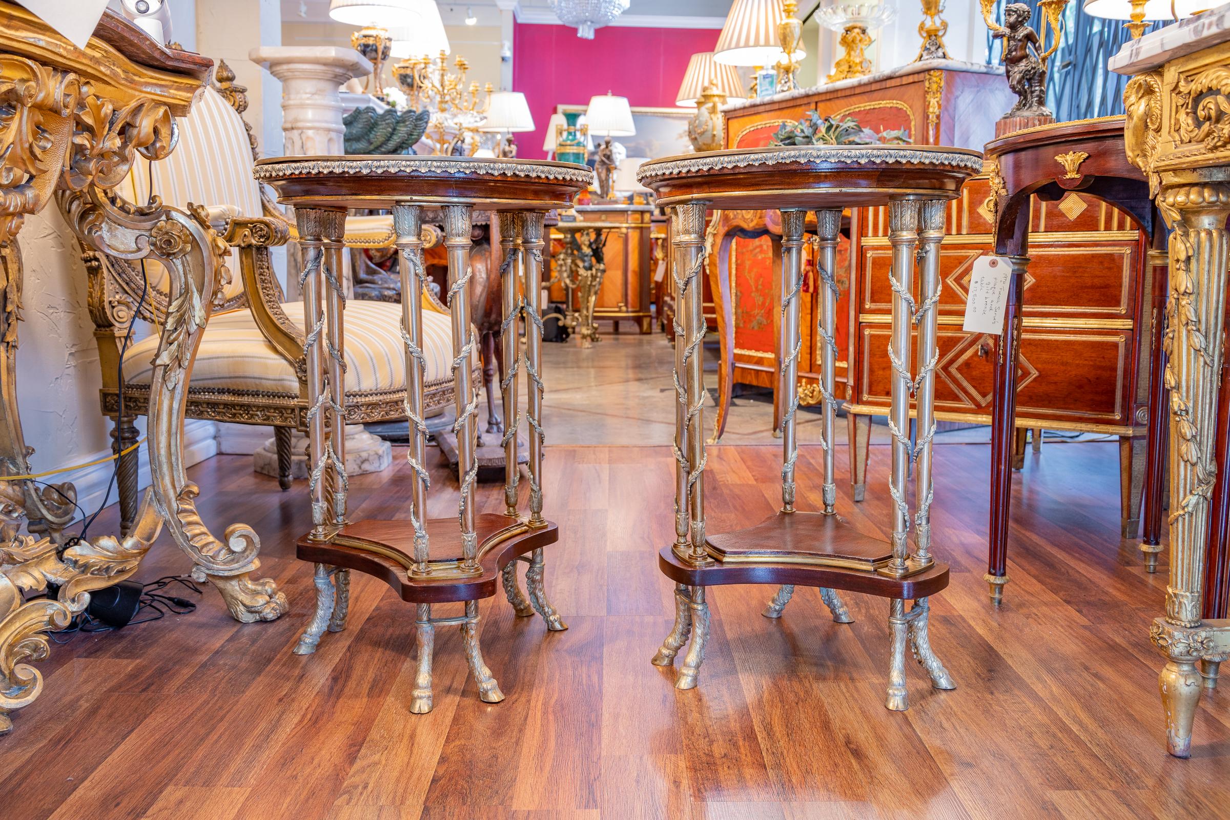 A fine pair of late 19th century French gueridon tables with gilt bronze columns and hoofed feet. Marble tops. After Adam Weisweiler.