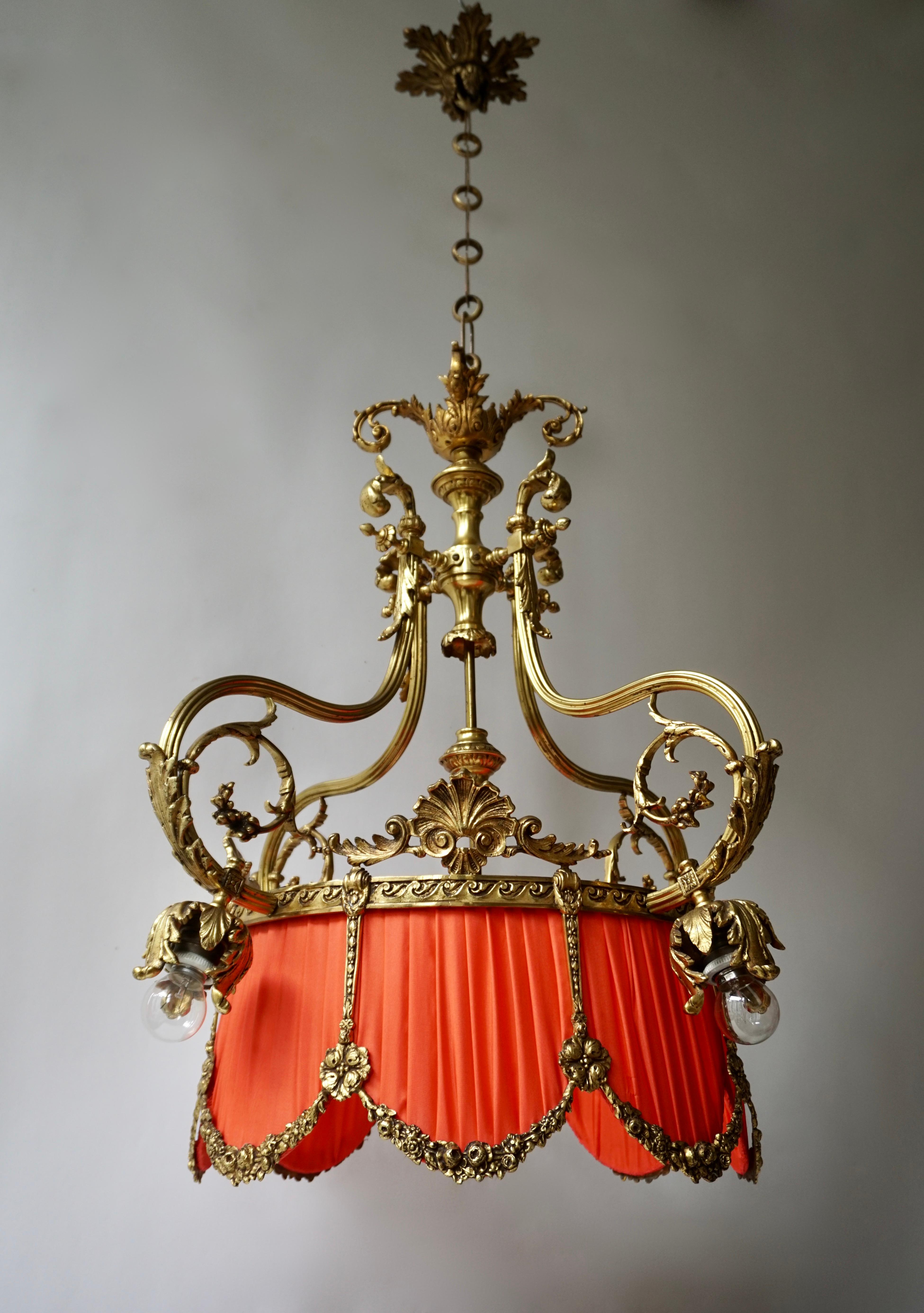 A French midcentury crown-shaped bronze five-light chandelier.
This elegant French chandelier from the beginning of the 20th century features an open circular base, which resembles that of a crown, has been elaborately stylized with guirlandes,
