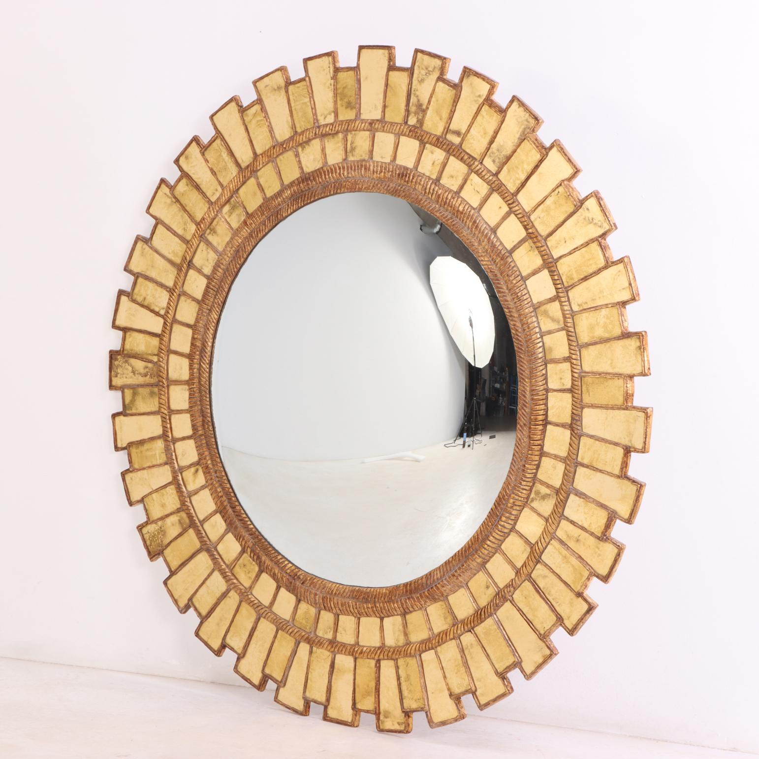 A striking gilt-glass geometric mirror, measuring an impressive 59+ inches in diameter. 
This exceptional piece is a variation of a “Gerbera” design, featuring an intricately radiating arrangement of individually set gilt-glass mirrored elements,