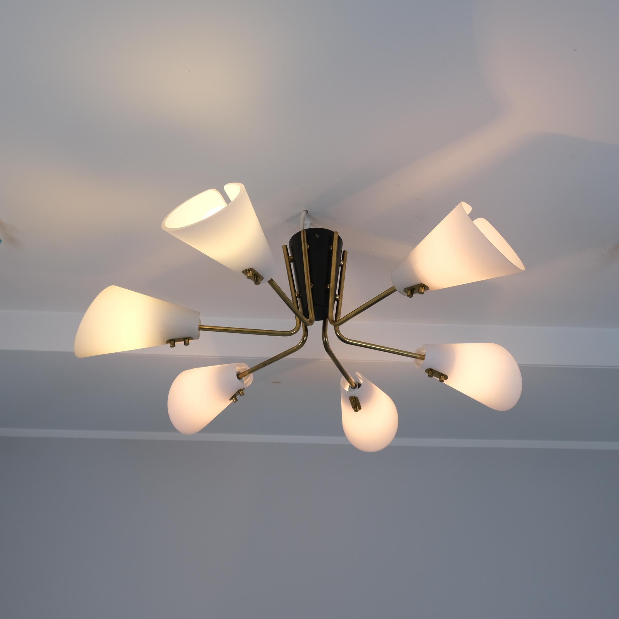 Une lampe brillante d'Itsu datant des années 1950. Ce type de lampe s'intègre bien dans tout type d'intérieur design. Le combo noir et blanc avec les tiges en laiton doré est simple, élégant, minimaliste et fonctionnel. Un look vintage supérieur qui