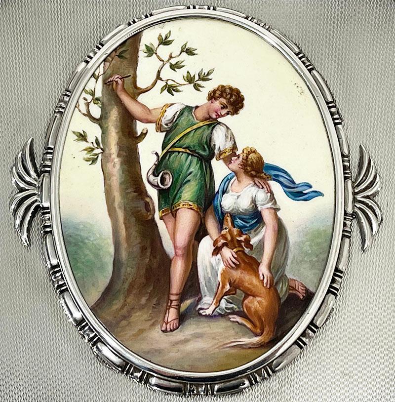 A beautiful square Guilloche Silver jewelery box by Emil Brenk

A silver box with guilloche and an oval enamel plaque with scene of a romantic couple. The man standing next to the tree and the woman kneeling next to the dog. The box stands on low