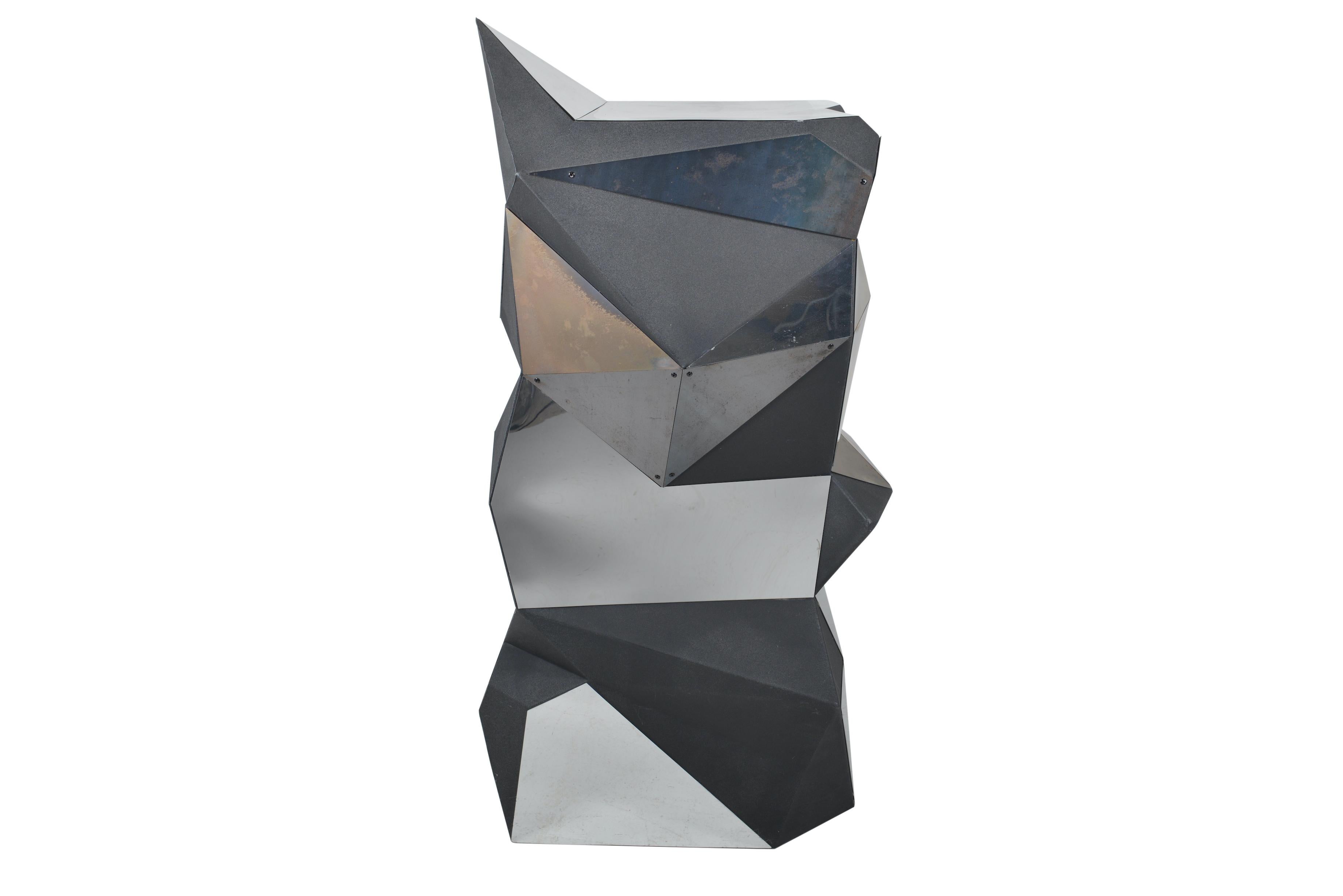 A quirky pedestal or object in black foam with plexi mirror shapes in triangular asymmetrical balance, forming a multifaceted curious object.