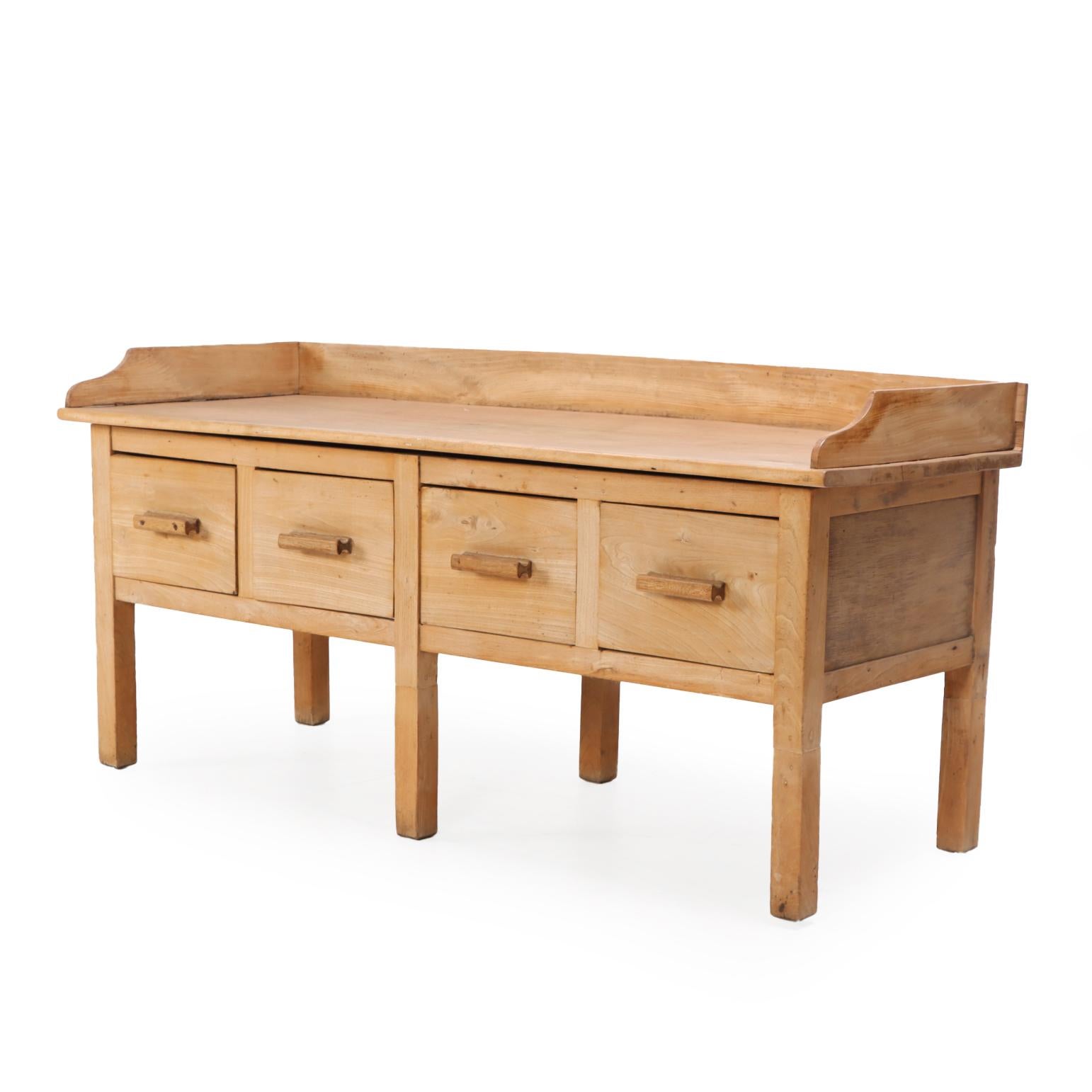 A substantial Belgian bakery table / work surface in solid maple! The rectangular top features a raised gallery edge and rests atop four spacious drawers, providing excellent storage. The case is supported by six square legs, offering strong