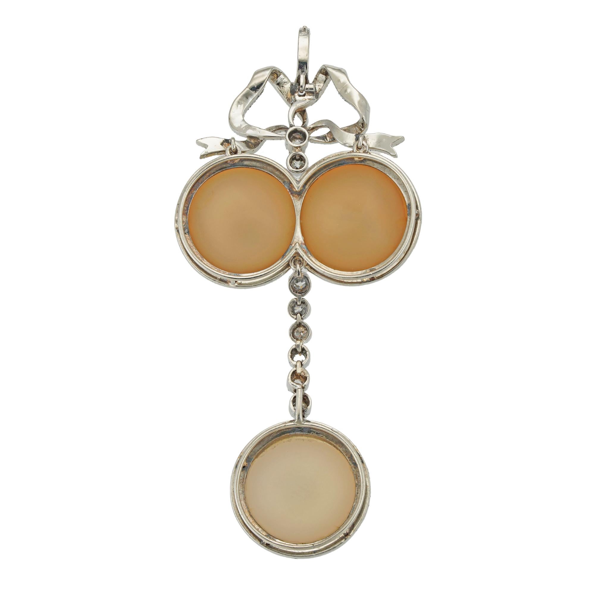 A Belle Epoque chalcedony and diamond pendant, in neoclassical style the two round cabochon-cut chalcedonies within a border of rose-cut diamonds, with rose-cut diamond-set bow surmount, suspending a line of six old European-cut diamonds terminating