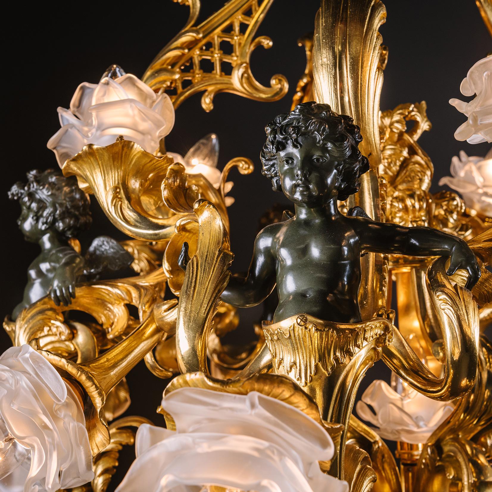 Un impressionnant lustre Belle Epoque en bronze patiné et doré à vingt-et-une lumières. Attribué à la Maison Millet, Paris. 

Ce lustre spectaculaire est doté d'un cadre sinueux en bronze doré. La couronne est ornée de feuilles d'acanthe et de