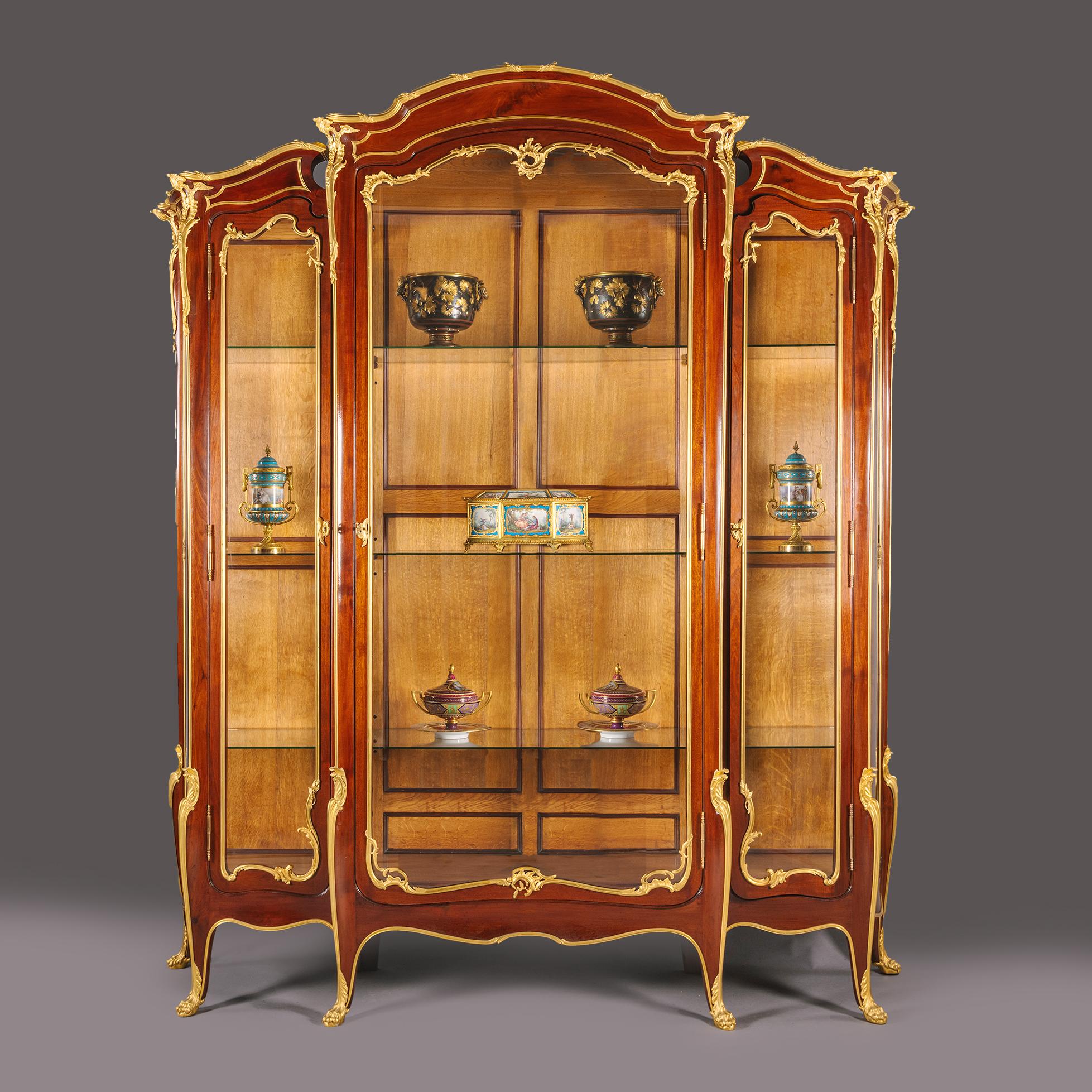 Vitrine de la Belle Epoque en acajou monté en vermeil par François Linke.  

De grandes proportions, avec une porte vitrée centrale en arc, flanquée de chaque côté d'une porte vitrée en retrait. Les panneaux latéraux sont vitrés. Chacun d'entre eux