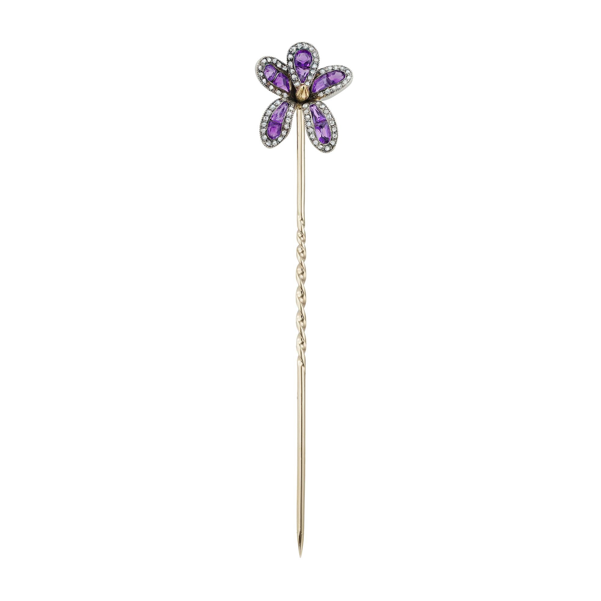 A Belle Époque amethyst and diamond iris stickpin by Lacloche, consisting of five peals each centrally-set with two faceted amethysts surrounded by small rose-cut diamonds, all mounted in platinum with yellow gold pin, signed Lacloche, circa 1910,