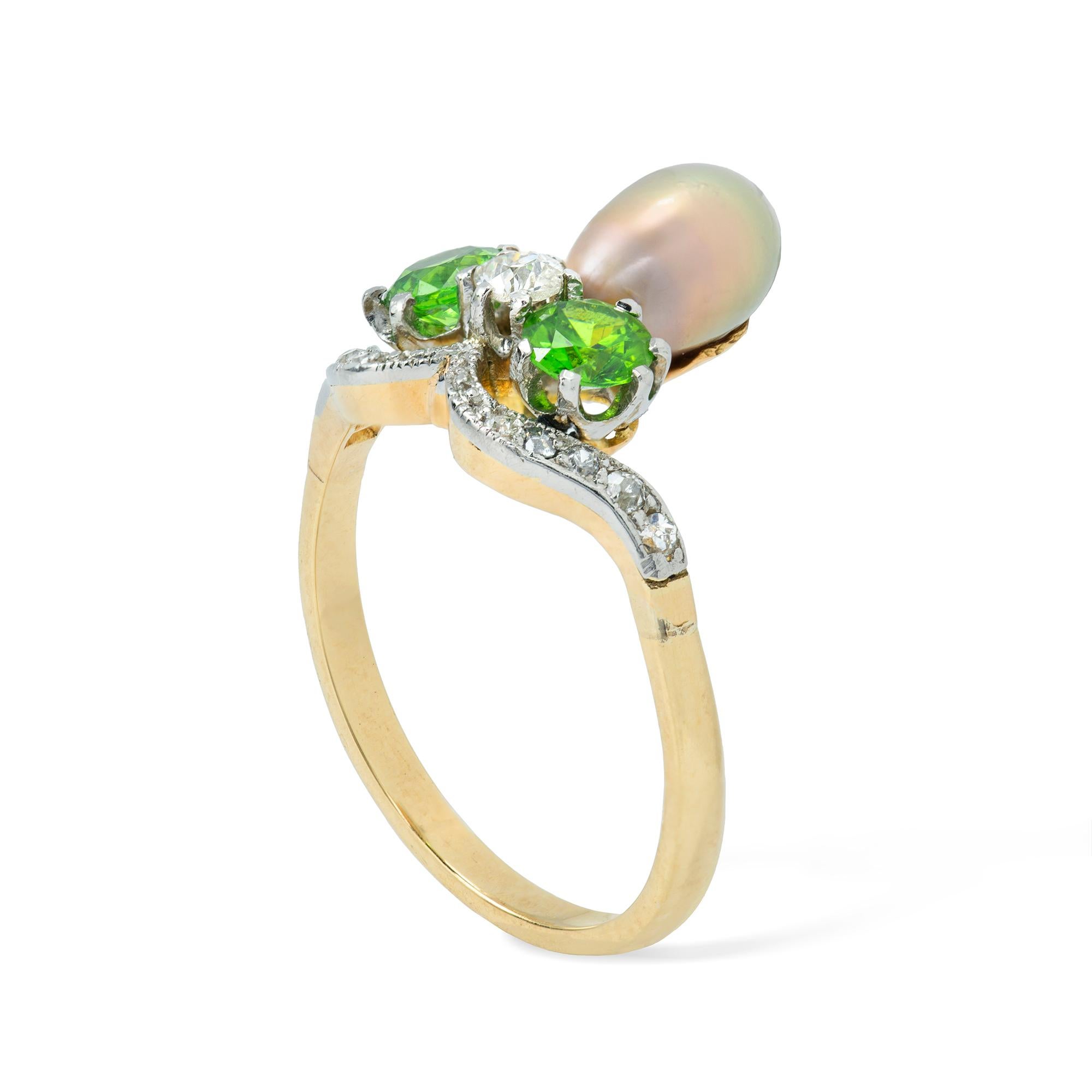 A Belle Epoque natural pearl, garnet and diamond aigrette ring, the greyish pink pearl accompanied by GCS report stating to be natural saltwater, set within two round faceted demantoid garnets and one old-cut diamond, the platinum and yellow gold