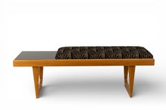 A Bench With a Cushioned Seat and Glass Table Top
