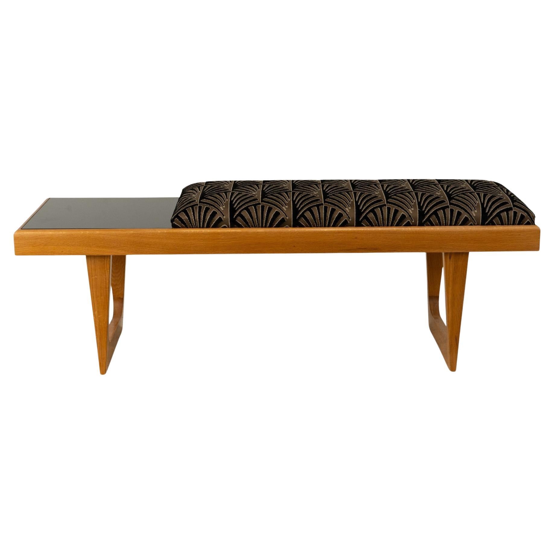A Bench With a Cushioned Seat and Glass Table Top