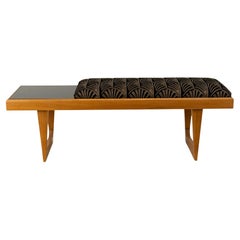 A Bench With a Cushioned Seat and Glass Table Top A Bench With a Cushioned Seat and Glass Table Top