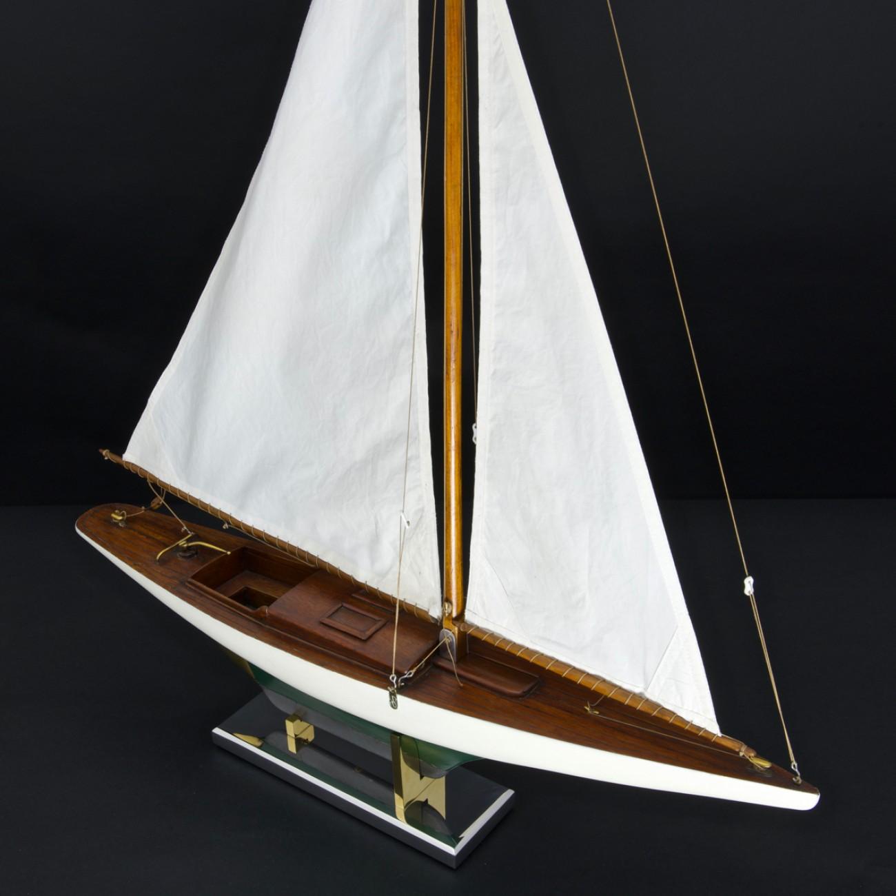 A sleek 1930s Bermudian rigged 24 inch pond yacht with painted hull and lead keel. The sails are copies of the originals and the model sits on a newly made metal stand. This model this particularly unusual as the cabin is fitted out with a table and