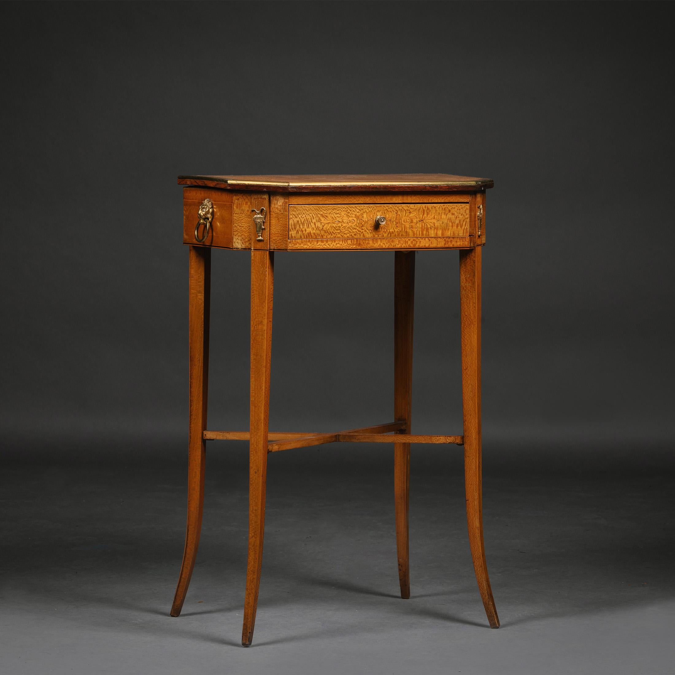 A Biedermeier Satin Birch Occasional Table.

The canted rectangular top above a frieze drawer and sides with lion mask handles, on swept legs joined by an 'X'-shaped stretcher.

Austrian, circa 1840.