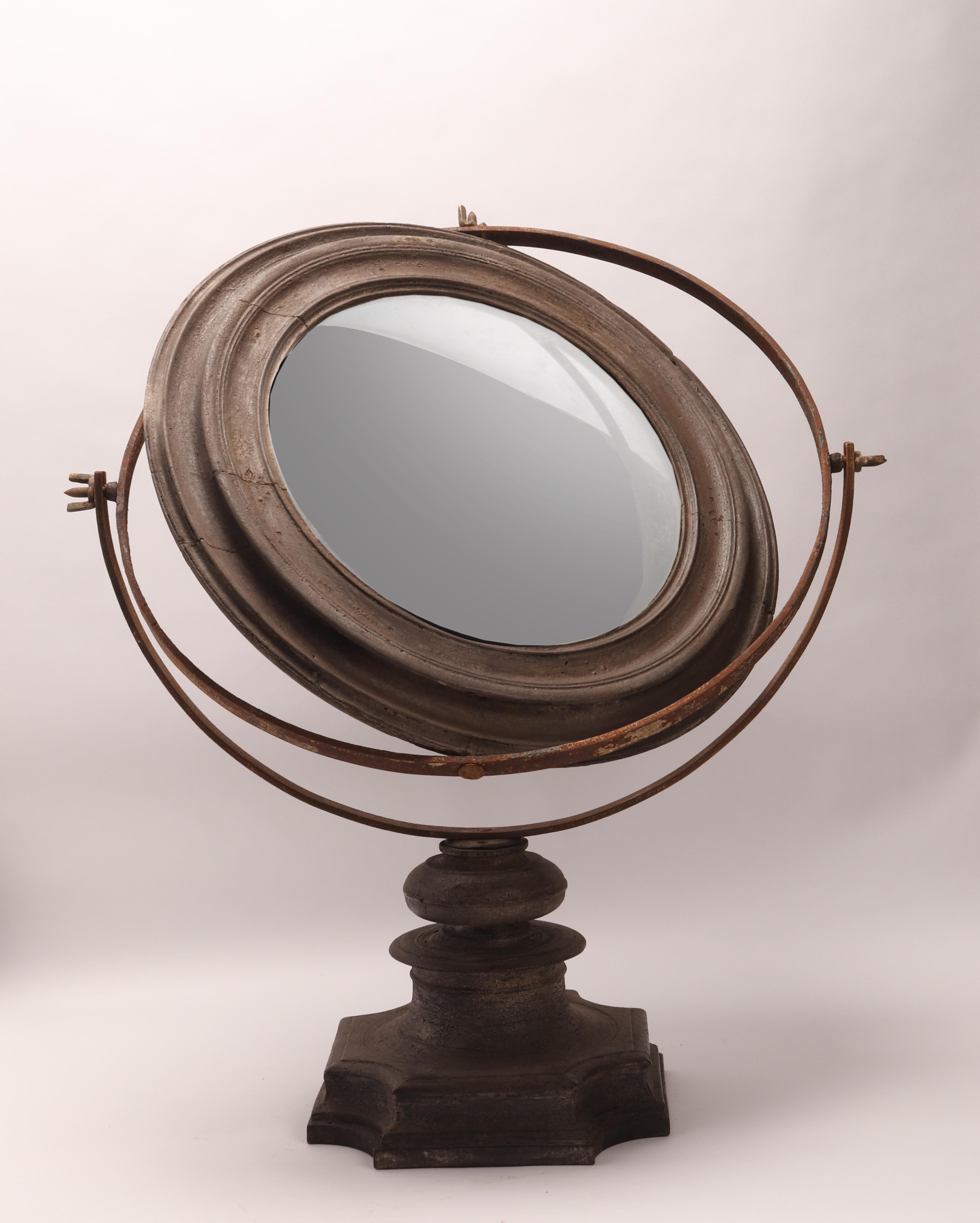 A big Wunderkammer round curved convex mirror with a black wooden frame mounted over a black wooden base. Italy beginning 18th century.