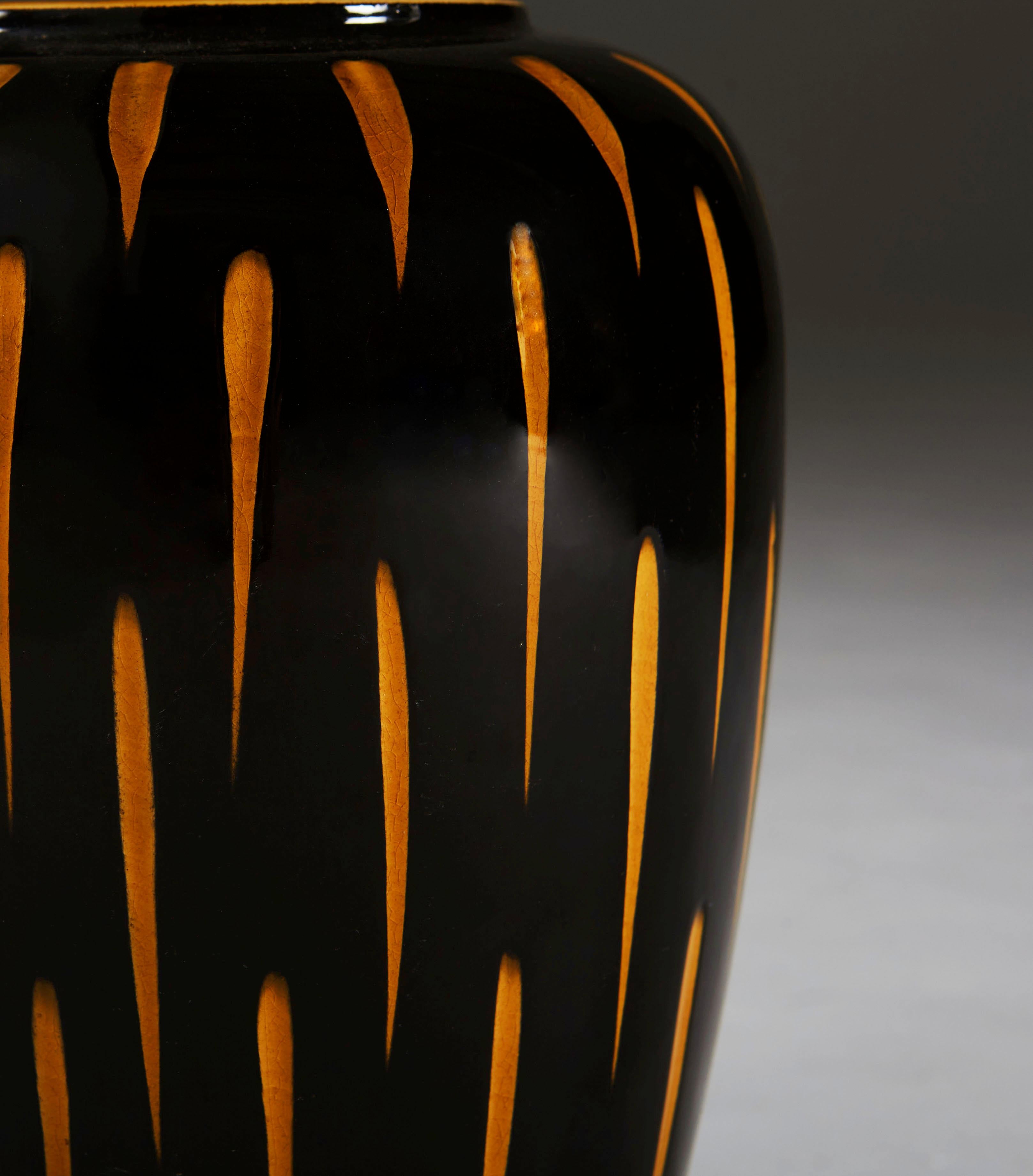 A mid-20th century Studio Pottery vase with black glaze layered over orange ground, the black glaze scraped away in dashes to reveal the orange below. Now converted as a lamp.

Please note: Lampshade not included.

Currently wired for the UK.