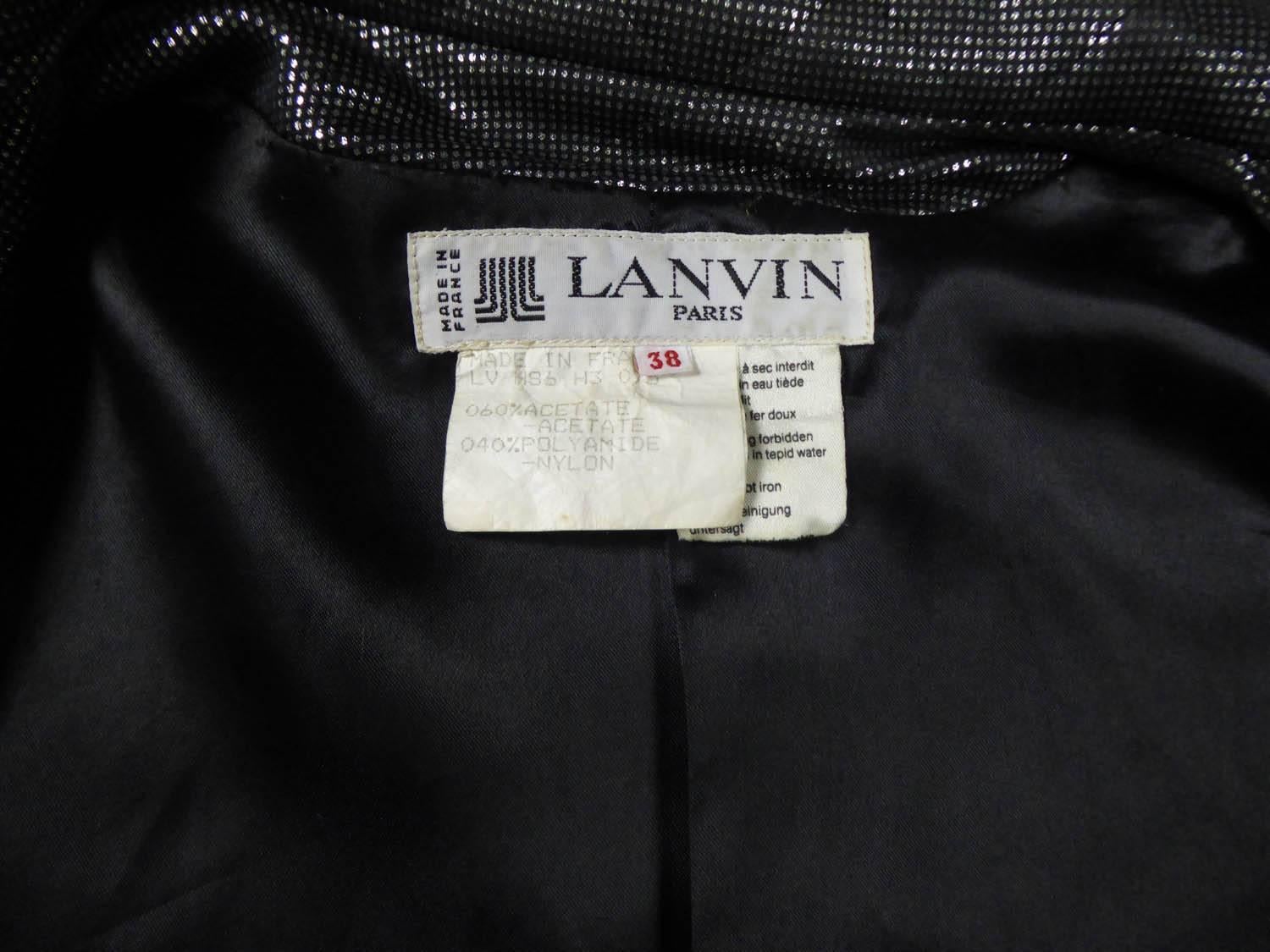 Circa 1980
Francia
Giacca in acetato nero stampata con pallini d'argento. Taglio raglan con maniche ampie strette ai polsi. Colletto Mao e due tasche in sbieco. Fodera in raso di seta nero. Si chiude sul davanti con un grande bottone in bachelite