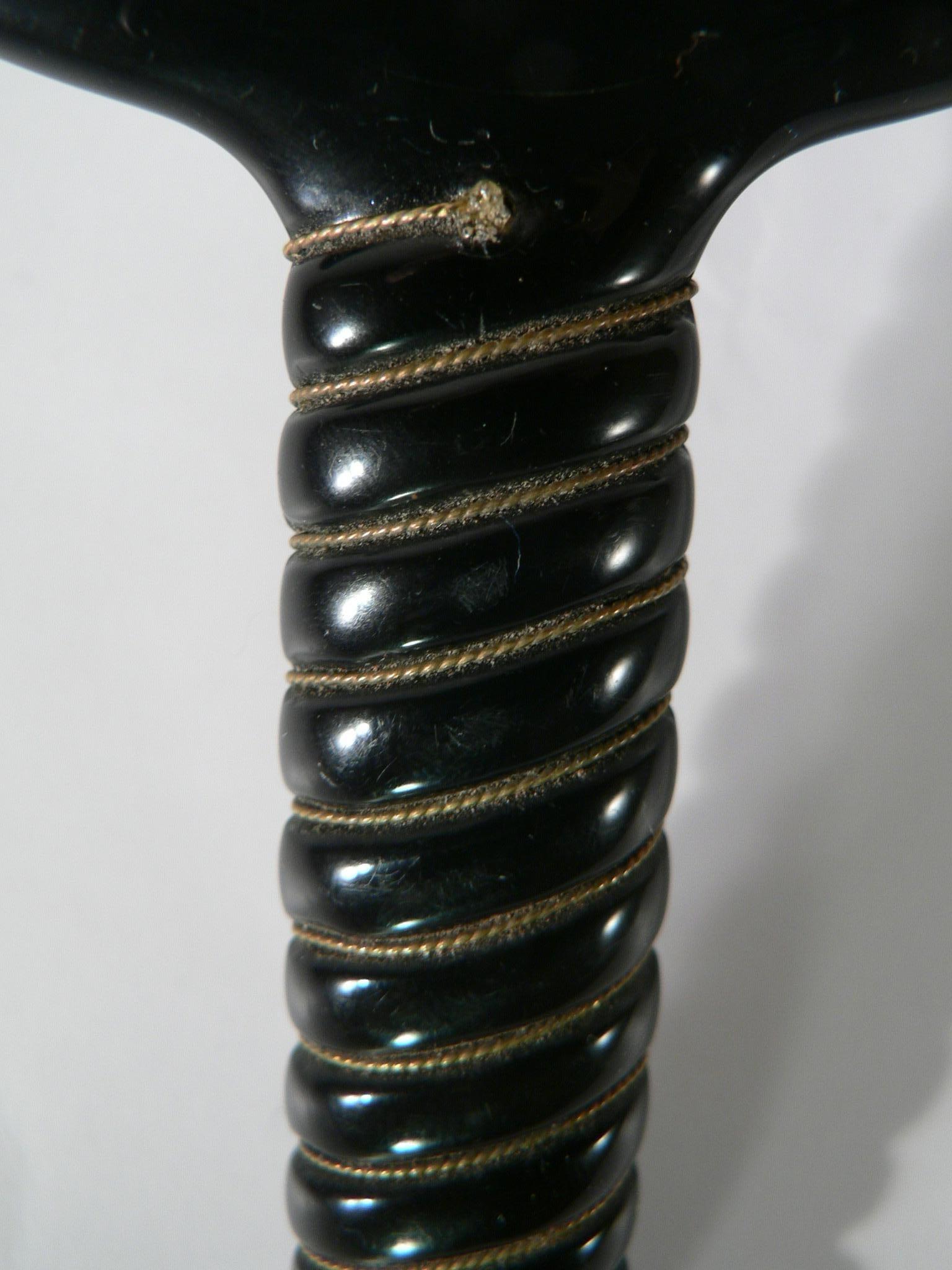 Ein eleganter schwarzer Handspiegel aus Bakelit aus den 1950er Jahren. Doppelseitig, eine davon mit Vergrößerungsspiegeln. Hübsche Details am Griff, mit einem Golddraht, der den Griff umgibt.