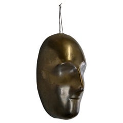 A black enamelled ceramic mask with bronze-gold highlights France 1950s