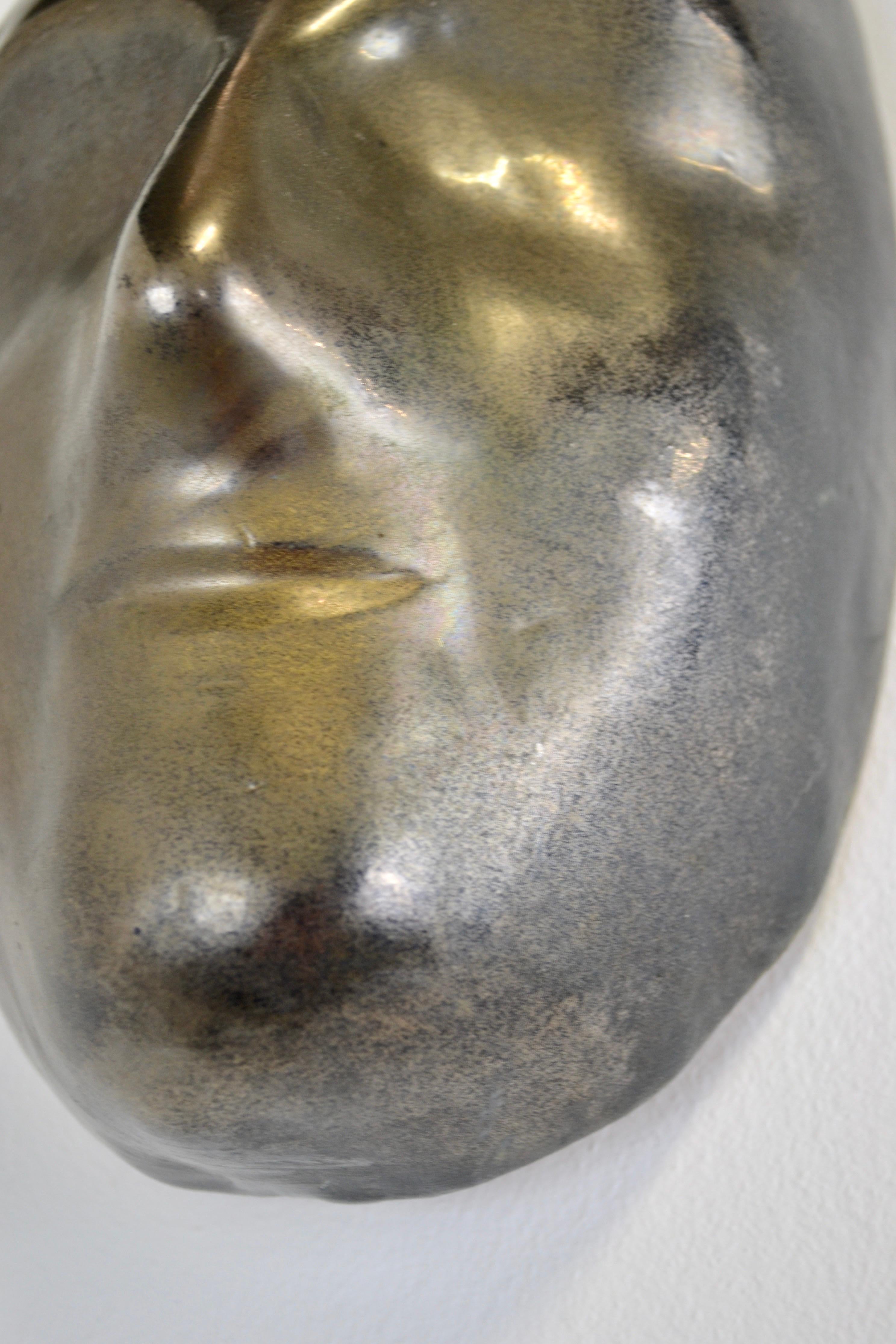 Mid-20th Century A black enamelled ceramic mask with bronze-gold highlights France 1950s For Sale