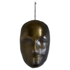 A black enamelled ceramic mask with bronze-gold highlights France 1950s