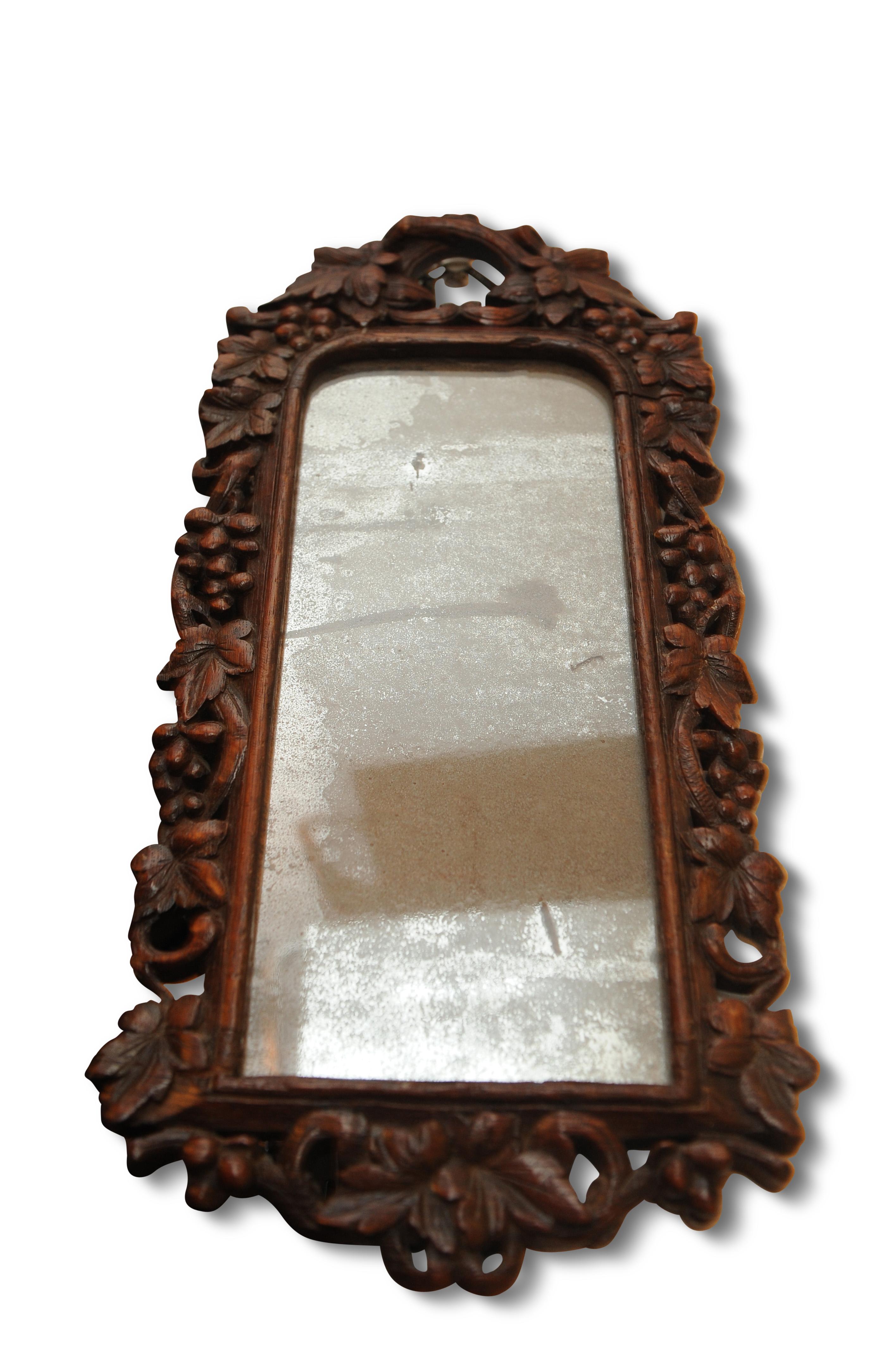 Unusual Black Forest, Bavarian oak wall mirror, the frame intricately carved with berries and foliage. With the original mercury glass mirror.

The piece retains the original mercury glass mirror, with a wonderful silvered patina to the face,