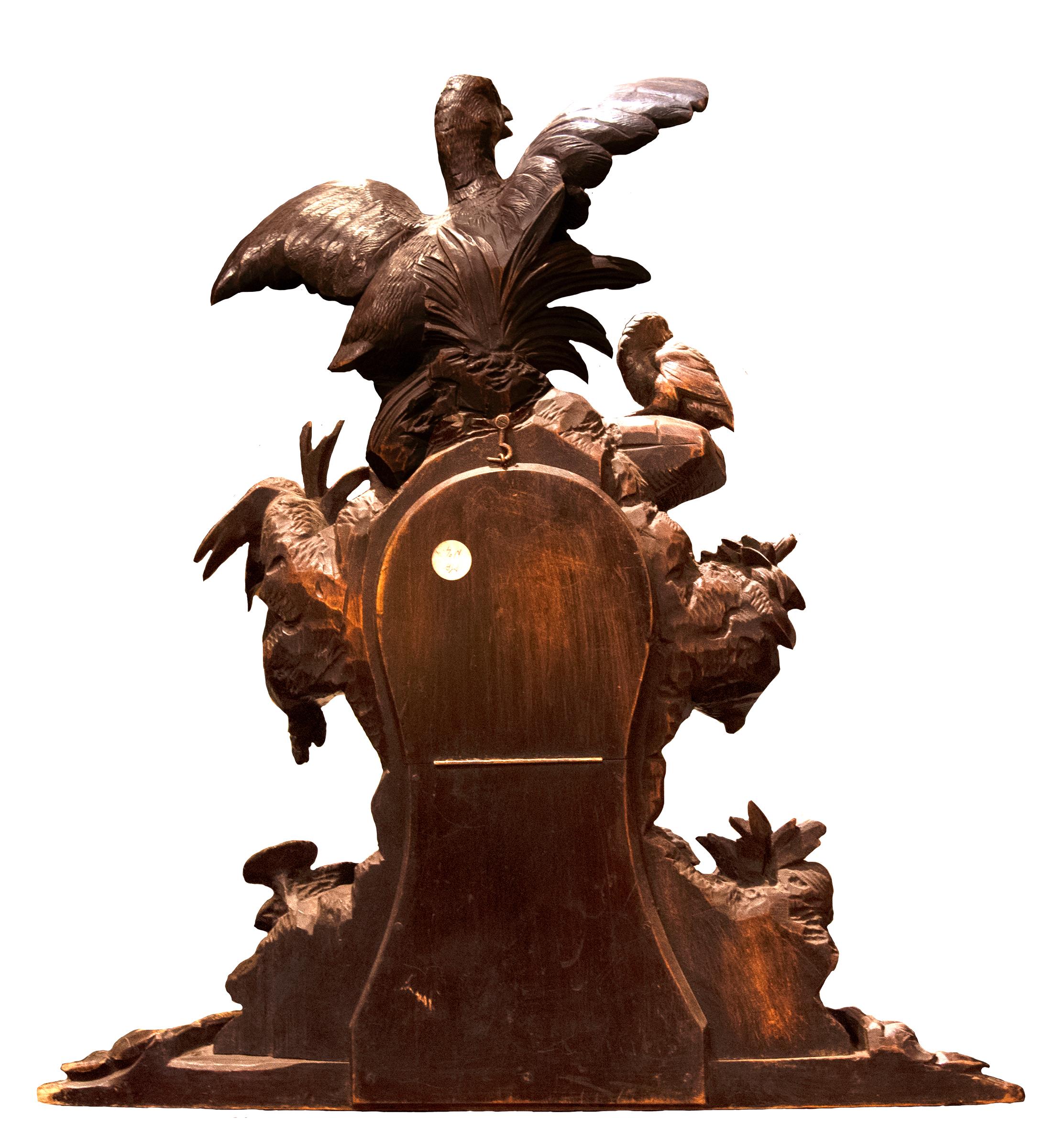 A nineteenth-century Swiss clock decorated with foliage and a family of birds.

Carved walnut in the Black Forest style, popular in the late nineteenth century.