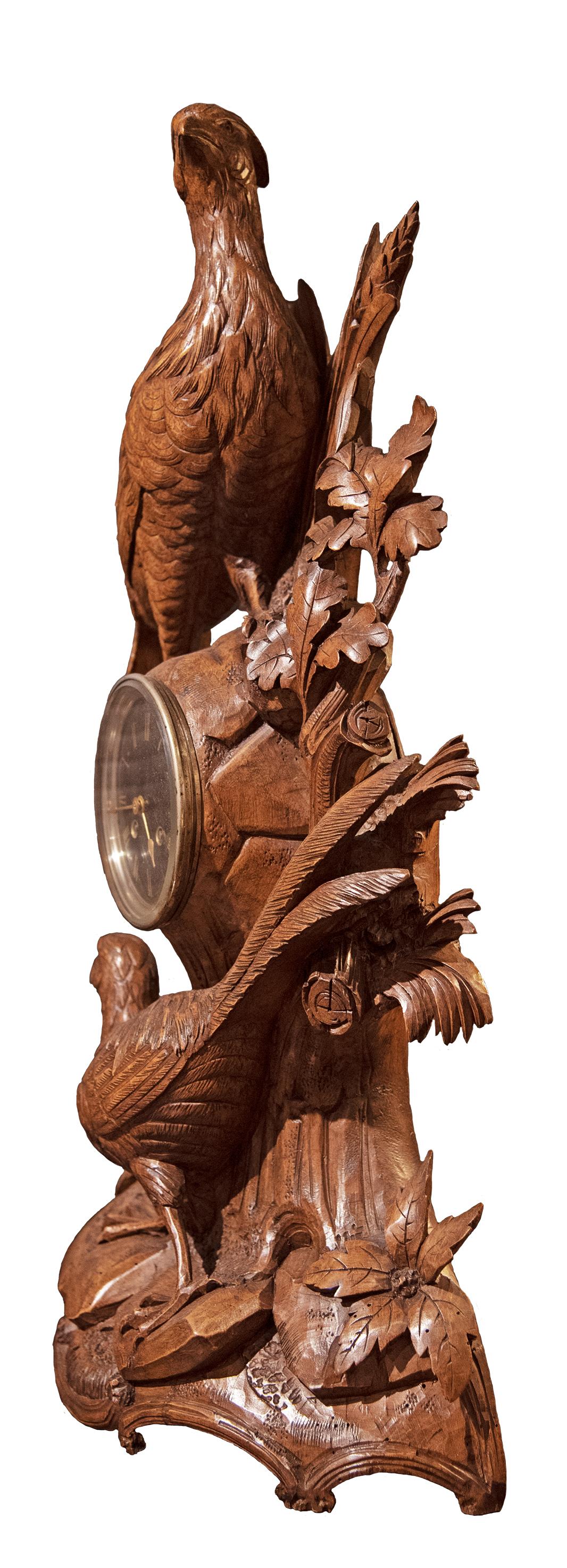 A nineteenth-century carved Swiss clock featuring two pheasants and vegetation.

Carved in the Black Forest style, popular in the late nineteenth century.
