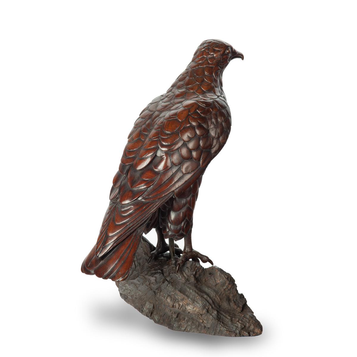 Modèle en bois de tilleul de la Forêt-Noire représentant un faucon, debout, les ailes repliées, sur un affleurement rocheux.  Suisse, vers 1910.


