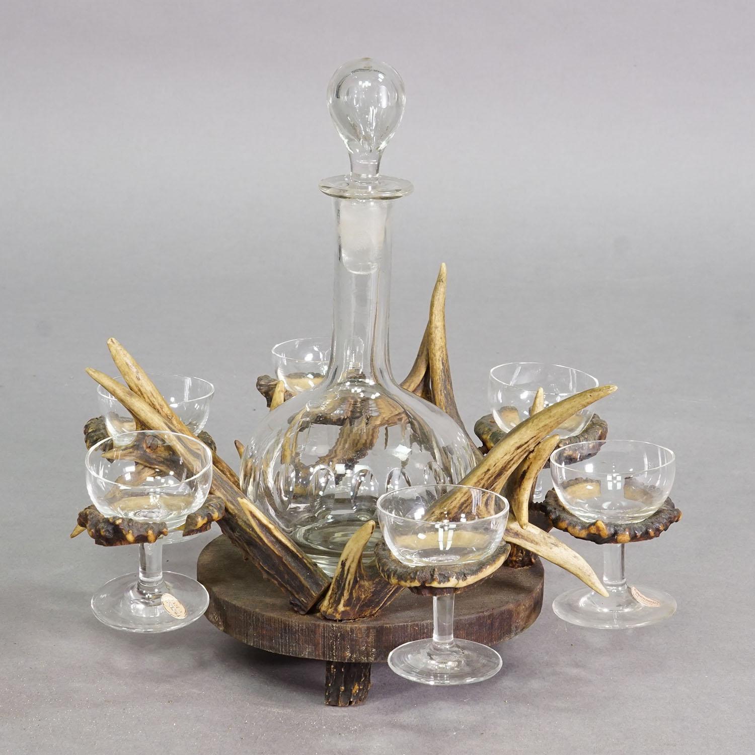 A Black Forest Rustic Liqueur Set with Decanter and Six Glasses

A rustic-style antique liqueur set consisting of a clear glass decanter with a matching stopper, surrounded by six small stemmed glasses. The set is mounted on a circular wooden base,