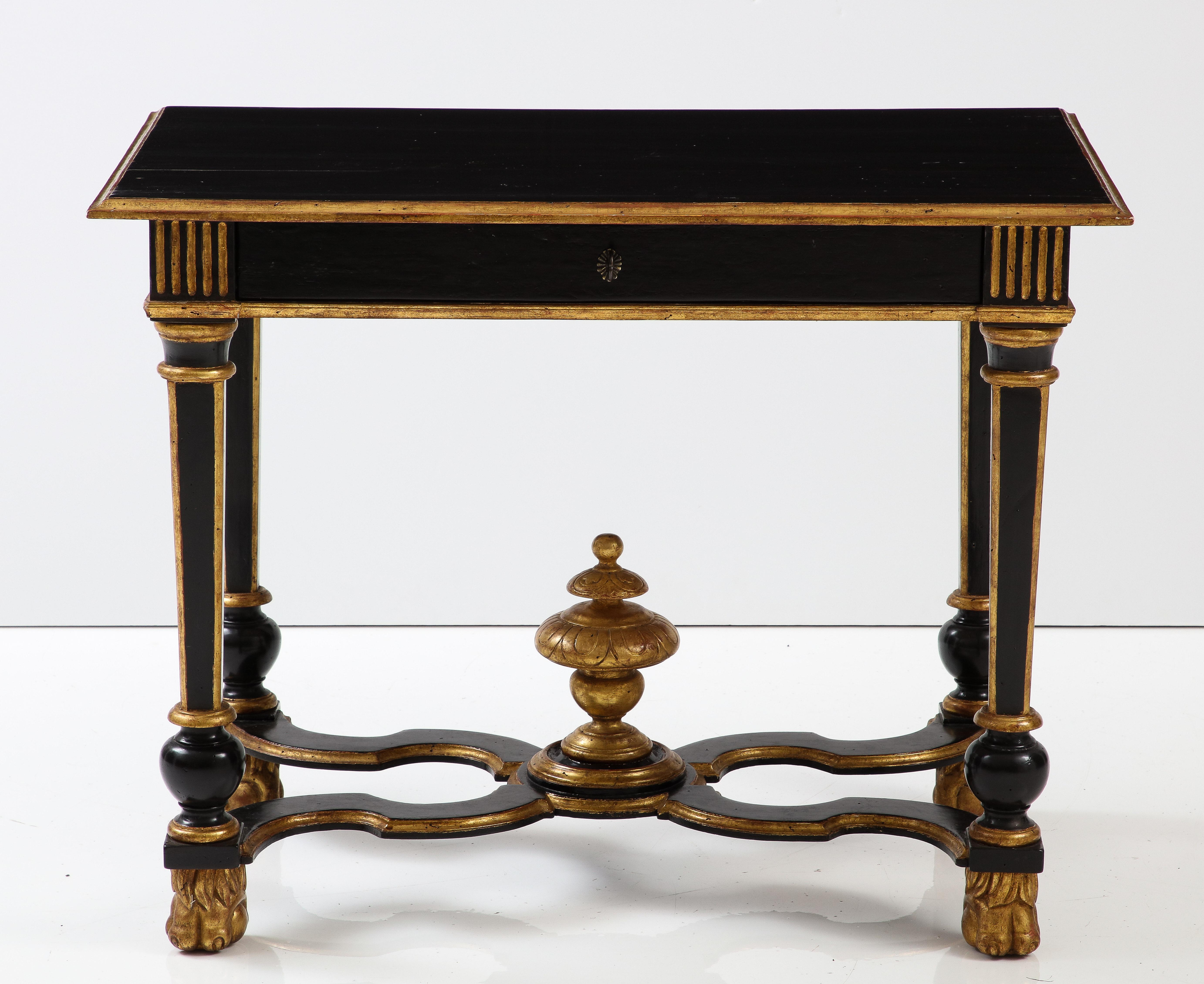 An elegant table that would make a statement in any room. Lacquered black with giltwood accents, the table features a molded top with reeded corners on the apron and is raised on turned, tapered legs with clawed feet. The piece de resistance is the