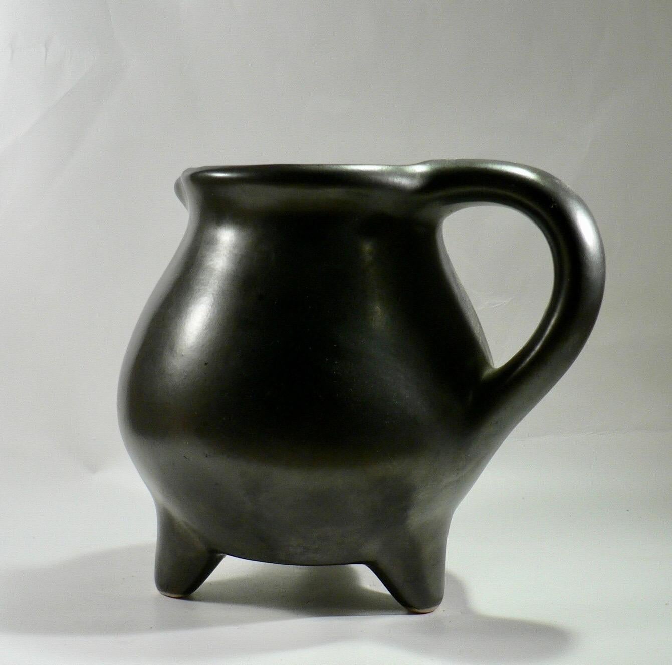 A bulging pitcher with a tripod base from Périgord pottery, featuring the form and glaze characteristic of French ceramics from the 1950s. In perfect condition.






