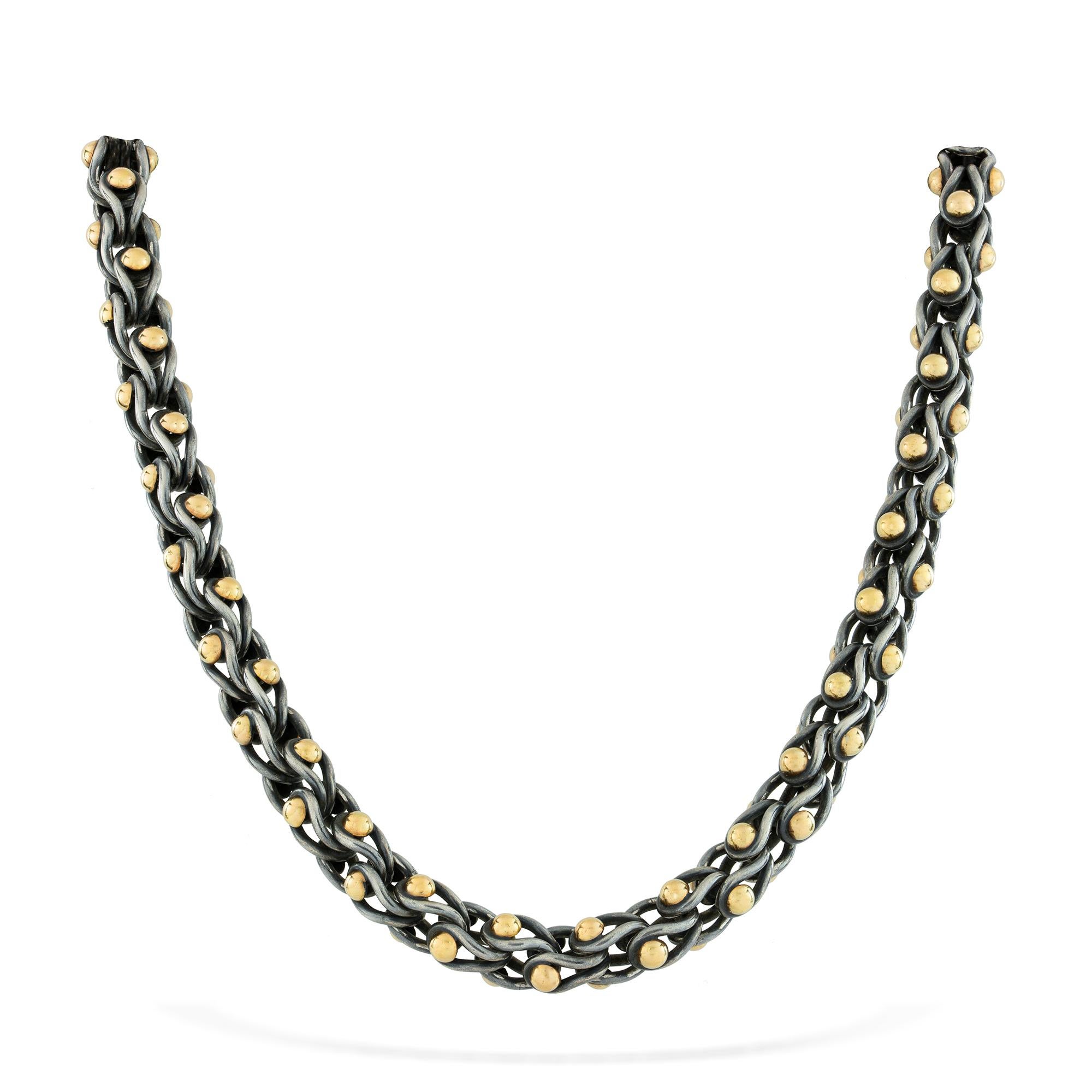 A black water ballet necklace, the sixty-eight U-shaped silver links in the form of a drop , each with two yellow gold hemispheres, handmade by Lucie Heskett-Brem the Gold Weaver of Lucerne, to a magnetic hidden clasp, hallmarked 18ct gold and