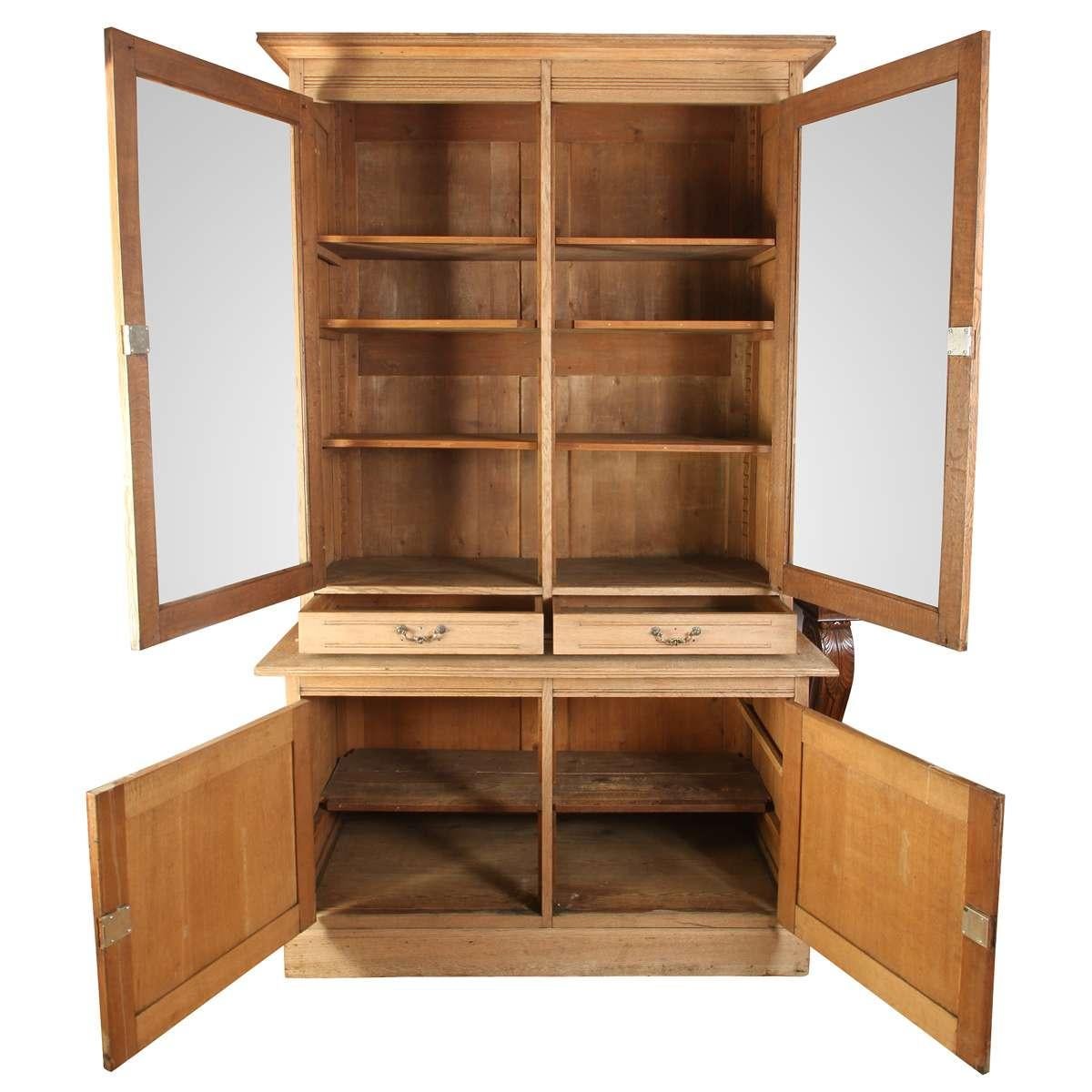 Fachada francesa de roble blanqueado. Puertas superiores acristaladas con estantes regulables, dos cajones y un espacioso armario inferior: una elegante solución integral de exposición y almacenamiento.