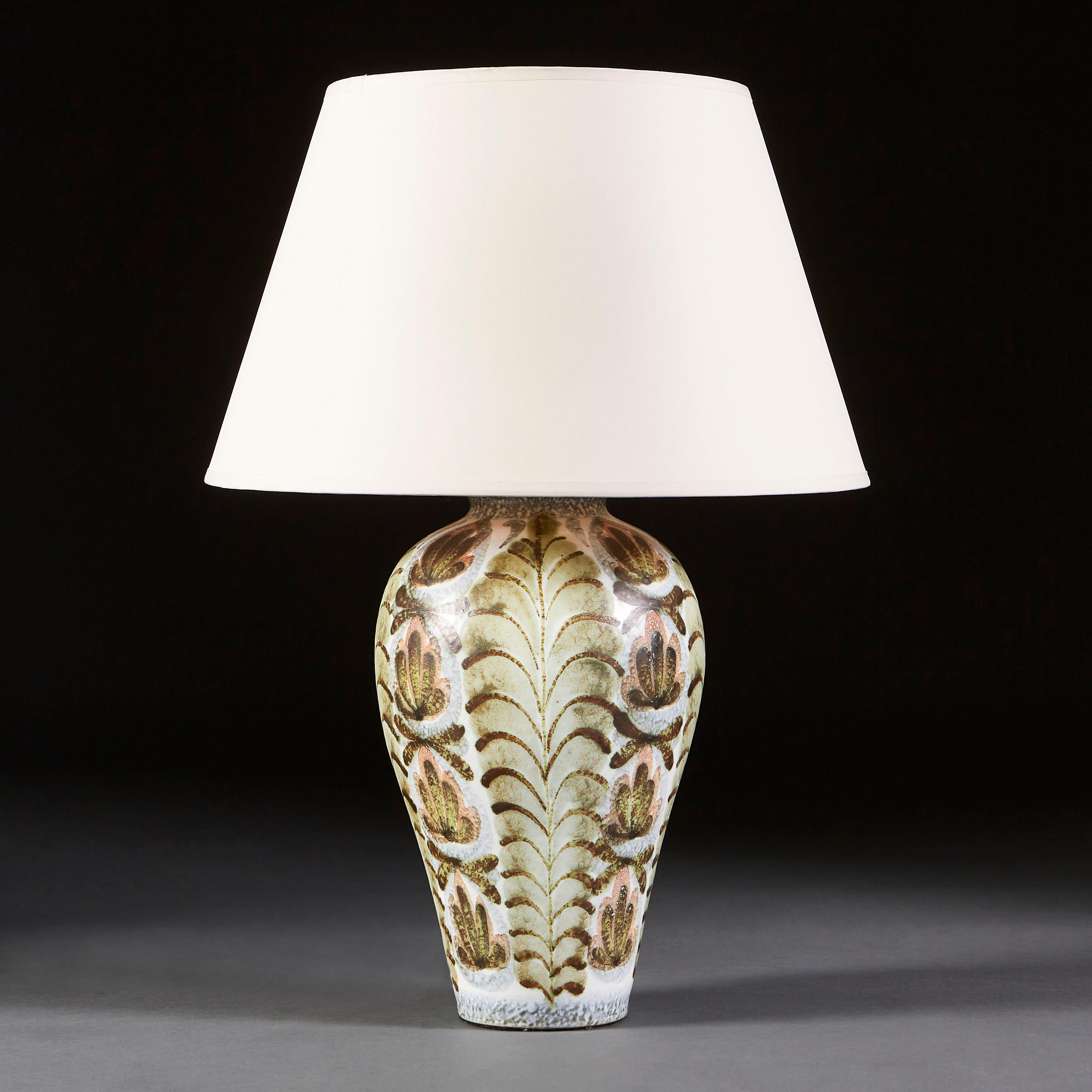 A Bloomsbury style lamp, painted with organic forms, alternating in vertical sections between stacked fan shapes and an abstract floral motif reminiscent of a lotus flower.

Currently wired for the UK.

Please note: Lampshade not included.