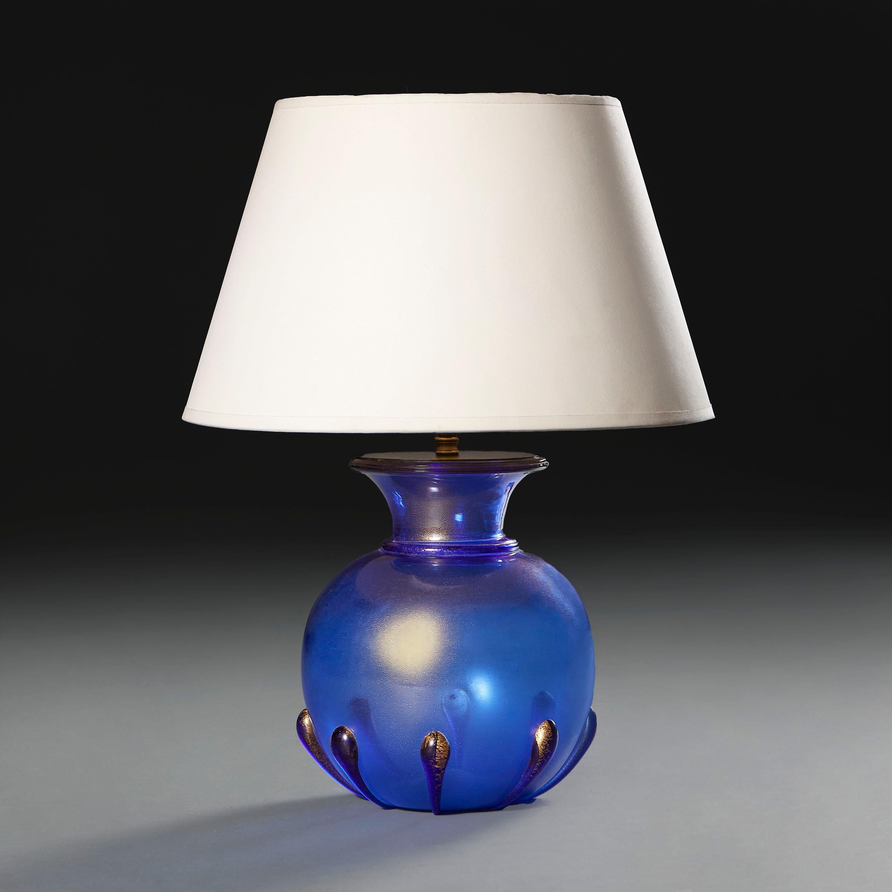 Italy, circa 1940

A mid twentieth century blue Murano glass vase with gold flecks throughout, with flared neck and drips to the base, now mounted as a lamp.

Photographed with 14” diameter pale cream card Pembroke lampshade.

Currently wired for