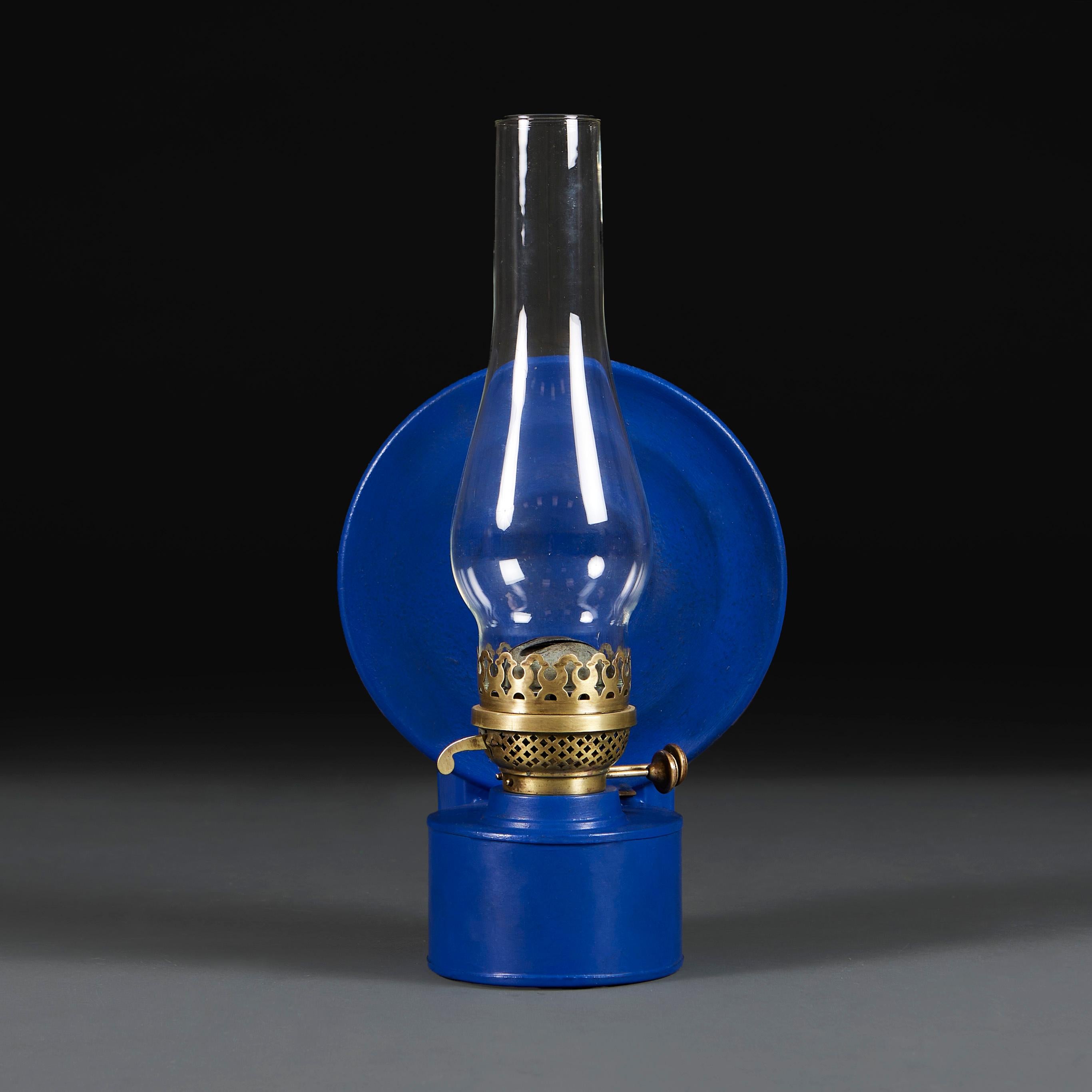 England, circa 1920

A wall mounted campaign storm lantern with a blue toleware circular backplate, pierced brass duplex burner and glass hurricane shade. 

Height 39.00cm

Width 21.00cm

Depth 15.00cm