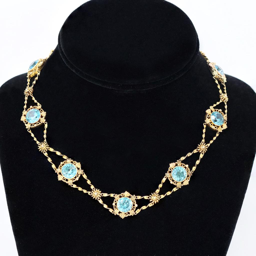 A stunning vintage station necklace circa 1920 featuring bezel set old European cut blue zircons displaying the desirable vibrant turquoise color so typical of old zircons. The necklace set in 14 karat yellow gold is designed as a sequence of gold