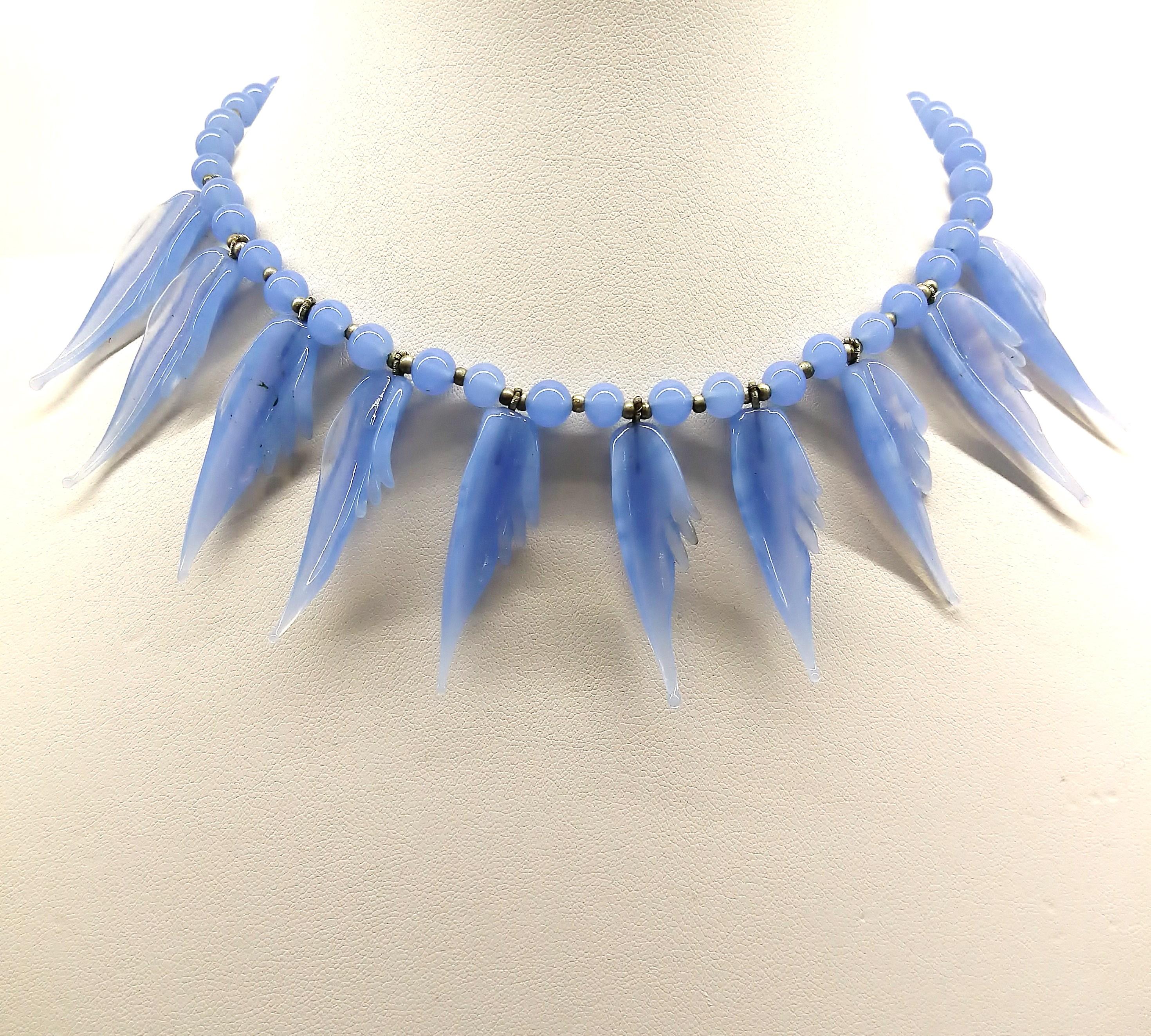 An unusual necklace and earrings in the softest hue of hyacinth or bluebell blue (similar to blue chrysoprase), made of hand blown glass beads and 'feather/angel wing' pendants, on both the necklace and earrings. The maker is unknown but most