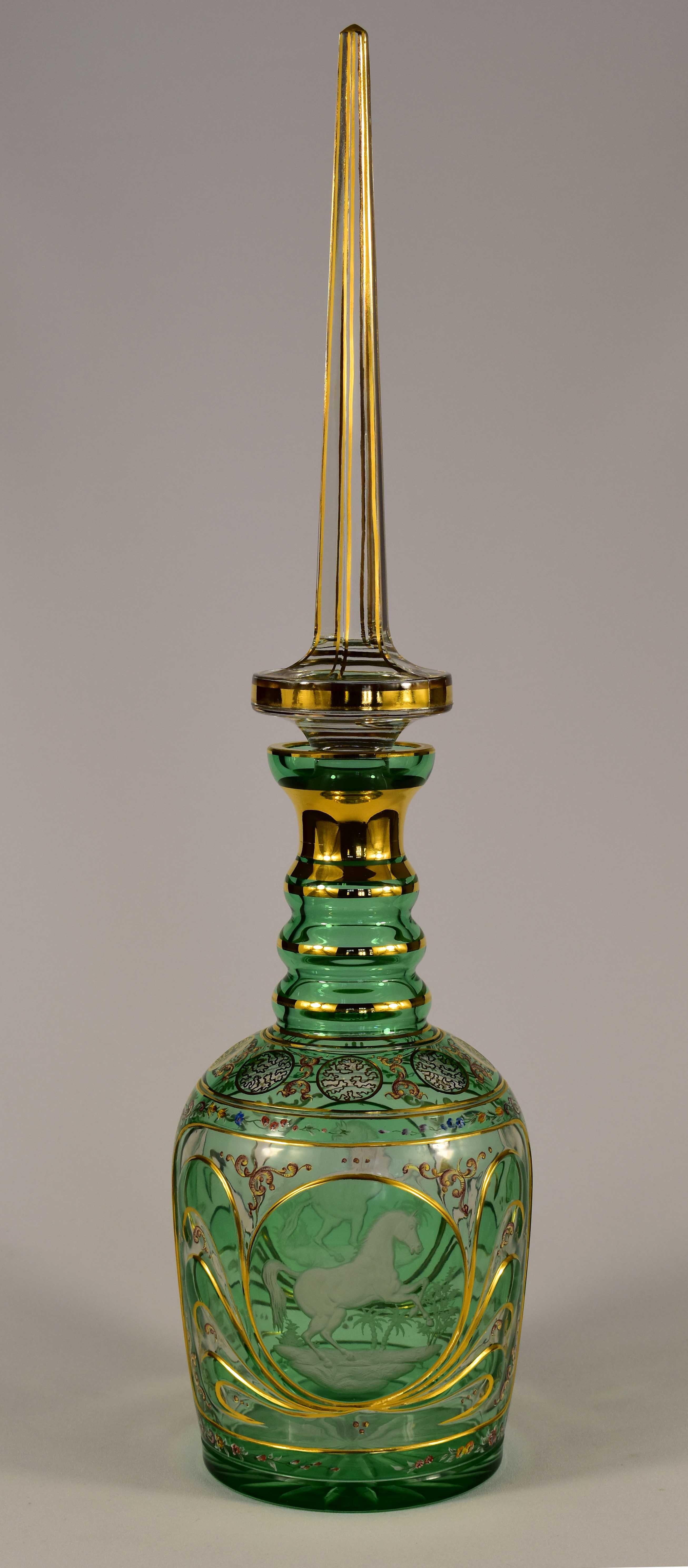 A Bohemian Persian overlay green and clear decanter probably 20th century, with triple ring neck and elongated spire stopper, This is a hand-ground, engraved and painted piece, Engraving showing horses in motion and painted flowers and ornaments, It