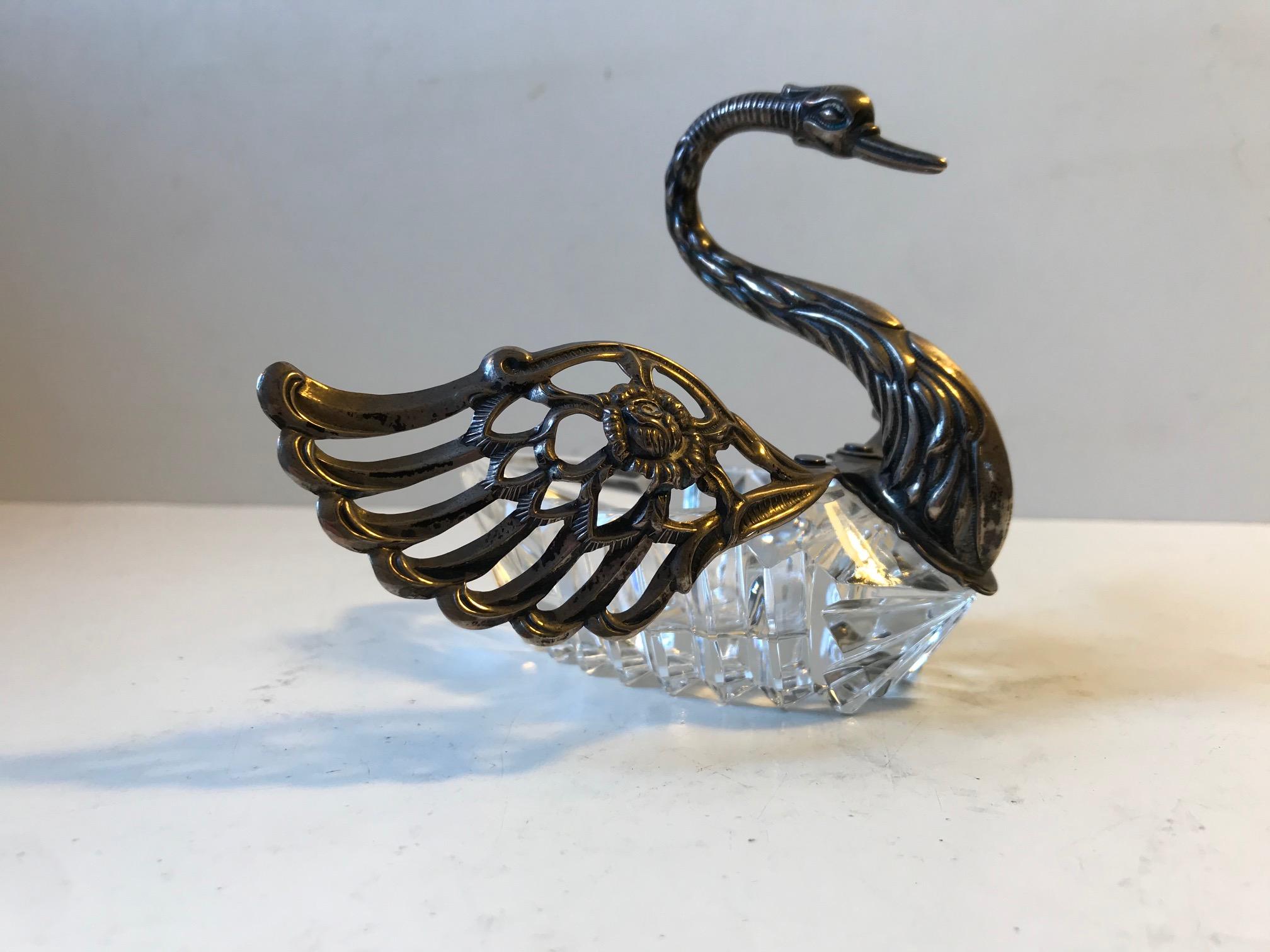 A Faberge inspired master salt cellar. A detailed Swan with articulated wings, solid neck, chest, head and a body in clear cut crystal - possibly Swarowski. It is stamped 855 indicating af purity of 85.5% of 100 parts of silver. The maker/designer