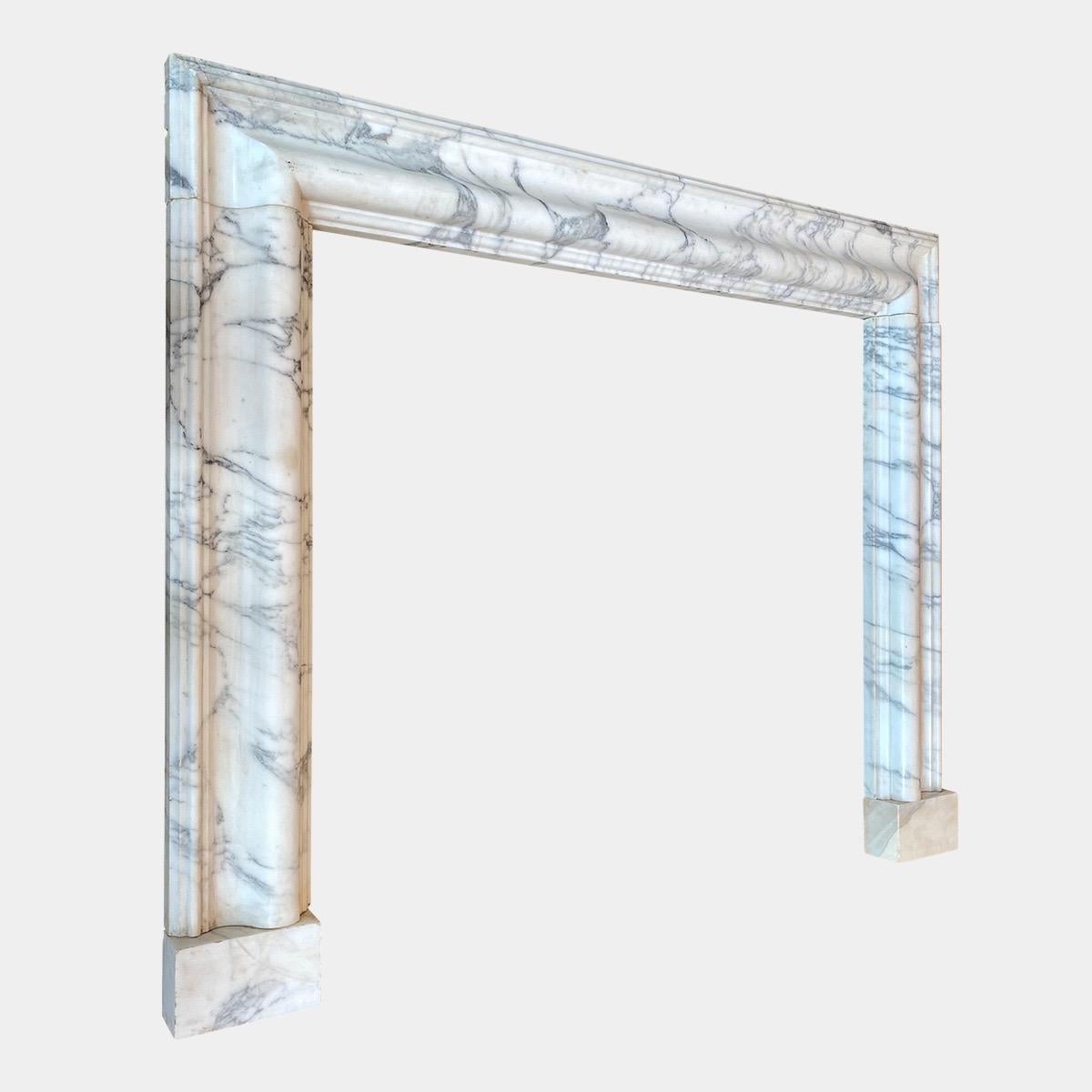 A 20th century re claimed Bolection in Italian Arabescato marble. The moulded frame with stepped outer and inner edge stood on separate foot blocks.

Opening size: 104.5cm W x 99.5cm H.