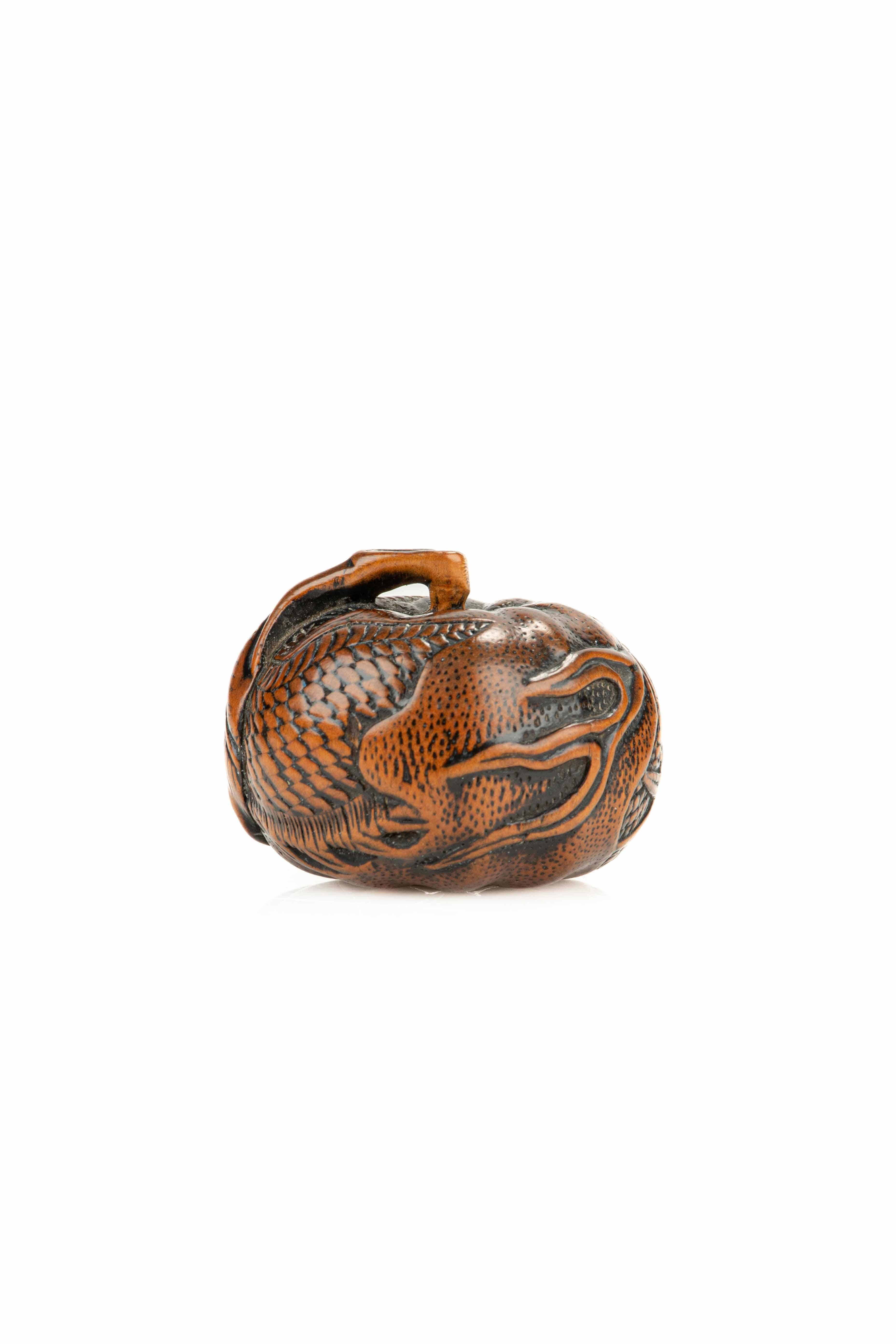 Inciso A boxwood netsuke depicting a mandarin with an engraved dragon, signed Tomomitsu in vendita