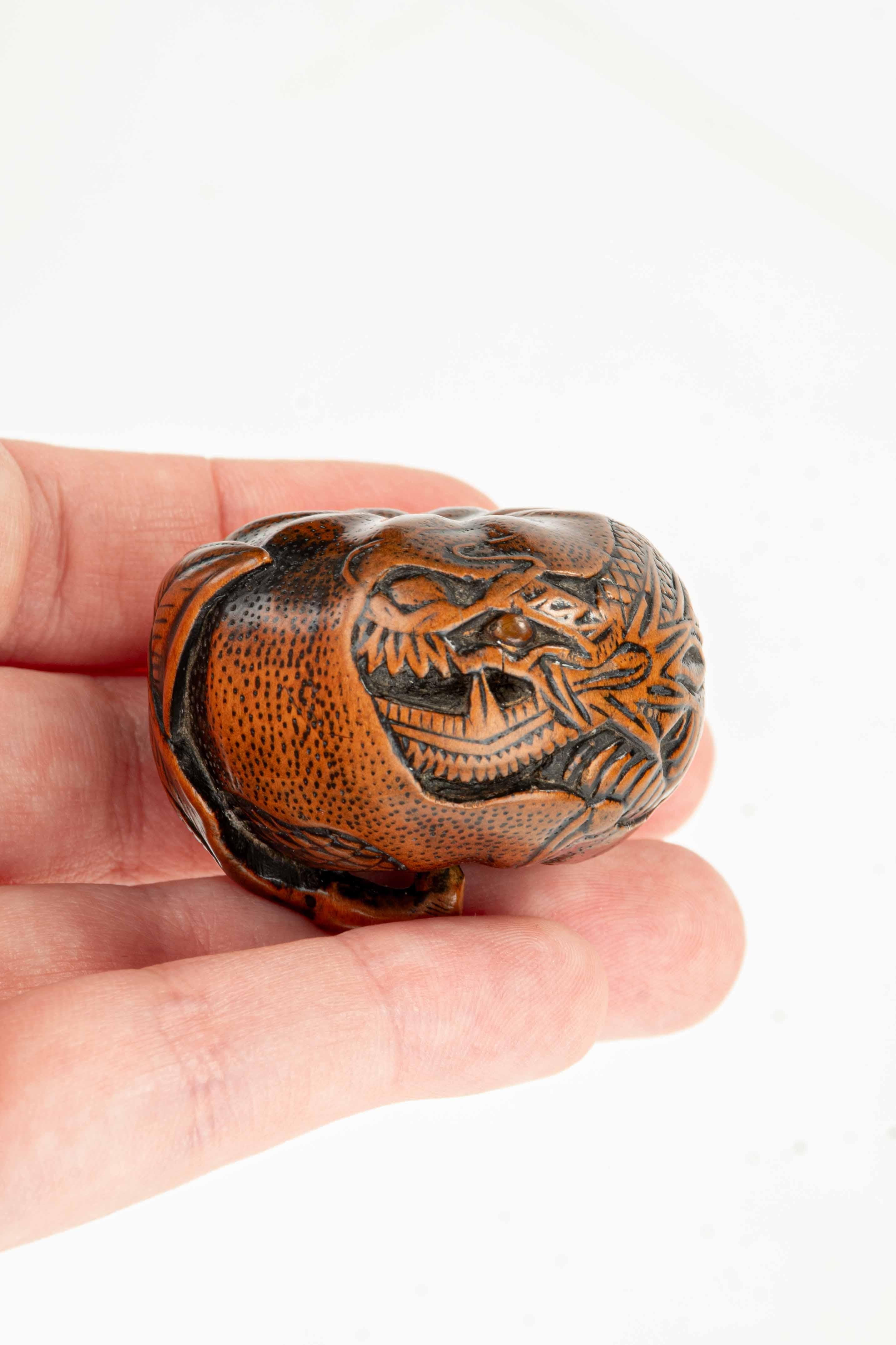 Bosso A boxwood netsuke depicting a mandarin with an engraved dragon, signed Tomomitsu in vendita