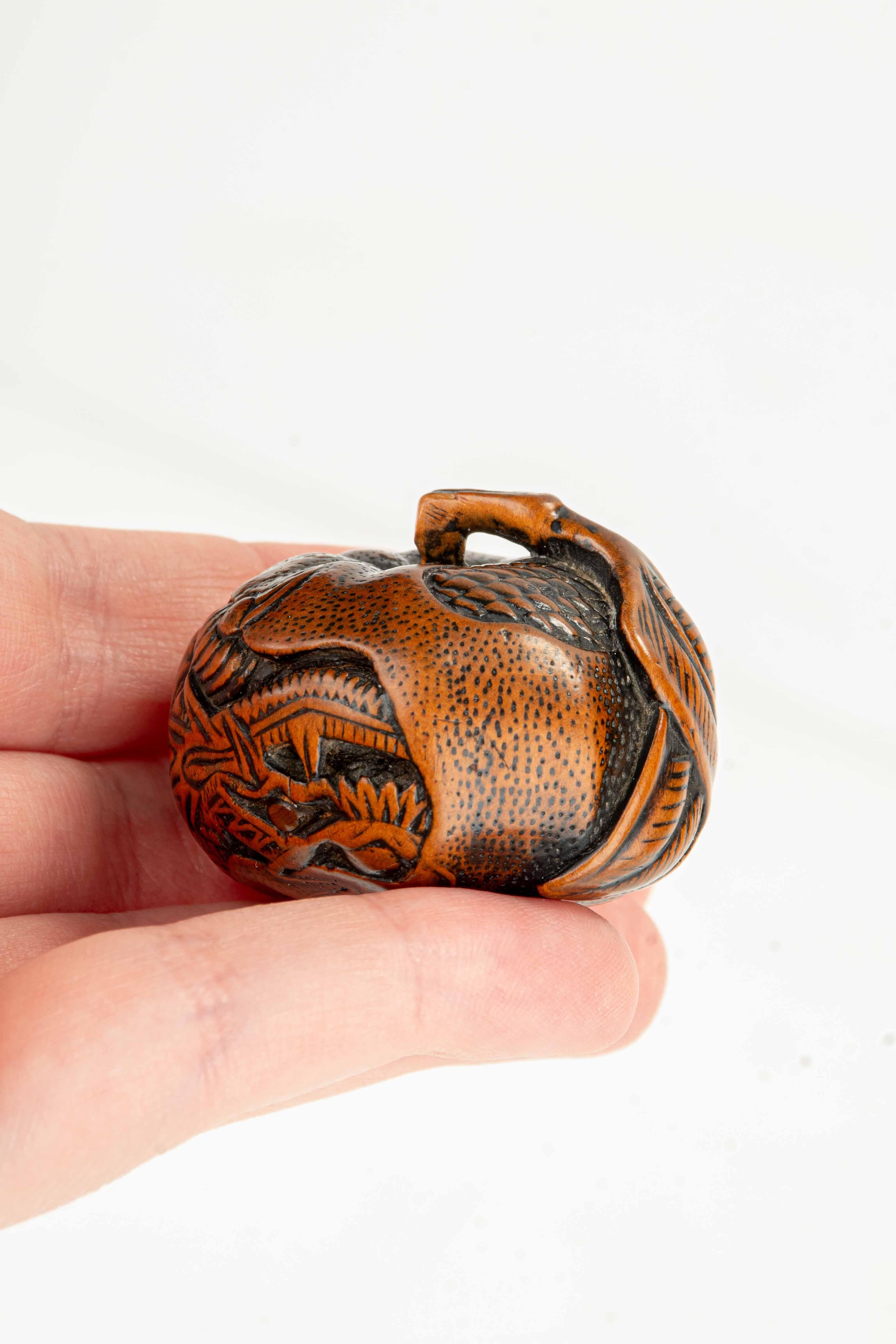 A boxwood netsuke depicting a mandarin with an engraved dragon, signed Tomomitsu in vendita 1